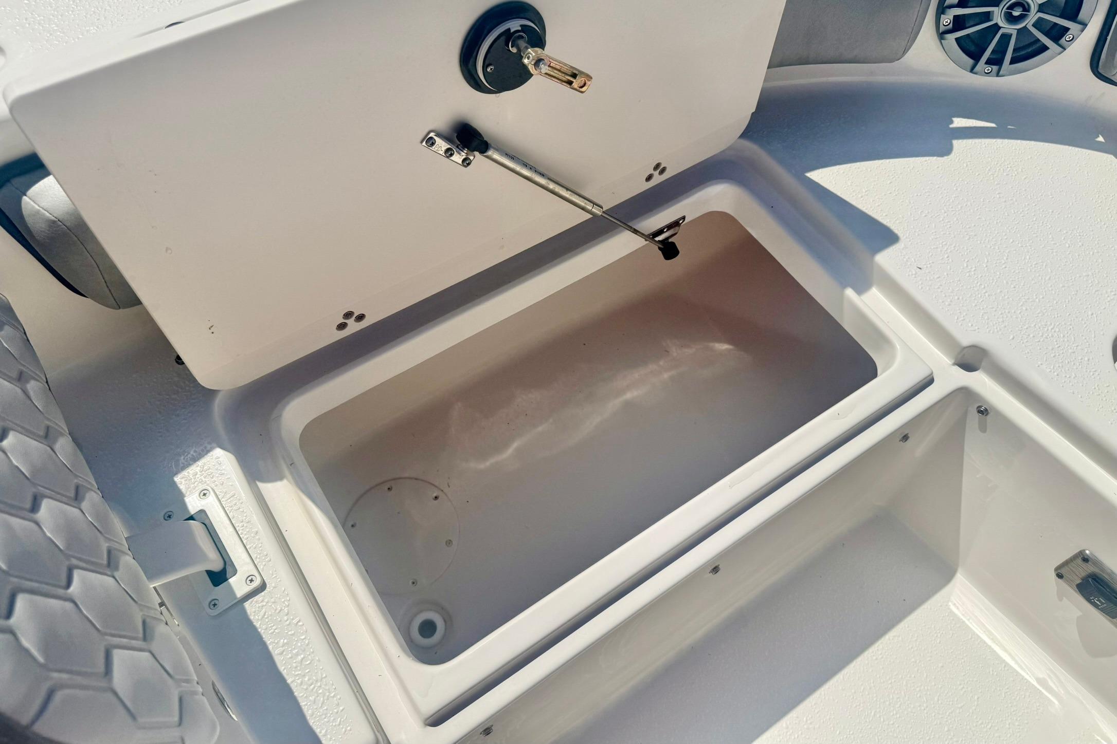 2026 Carolina Skiff 21 Ultra Elite boat storage compartment with open lid.