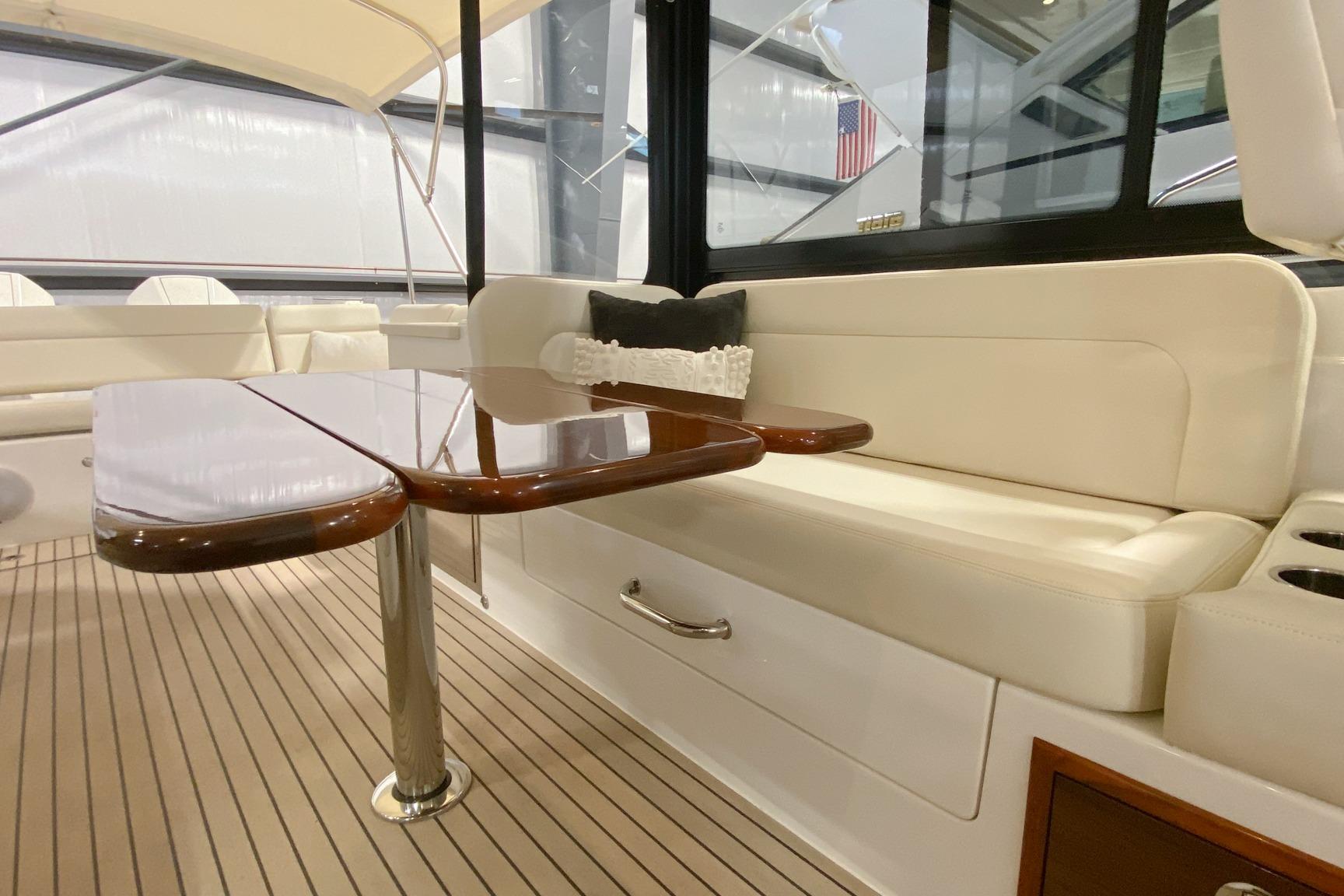 Luxurious interior of 2022 MJM 3 yacht with elegant seating and polished wooden table.