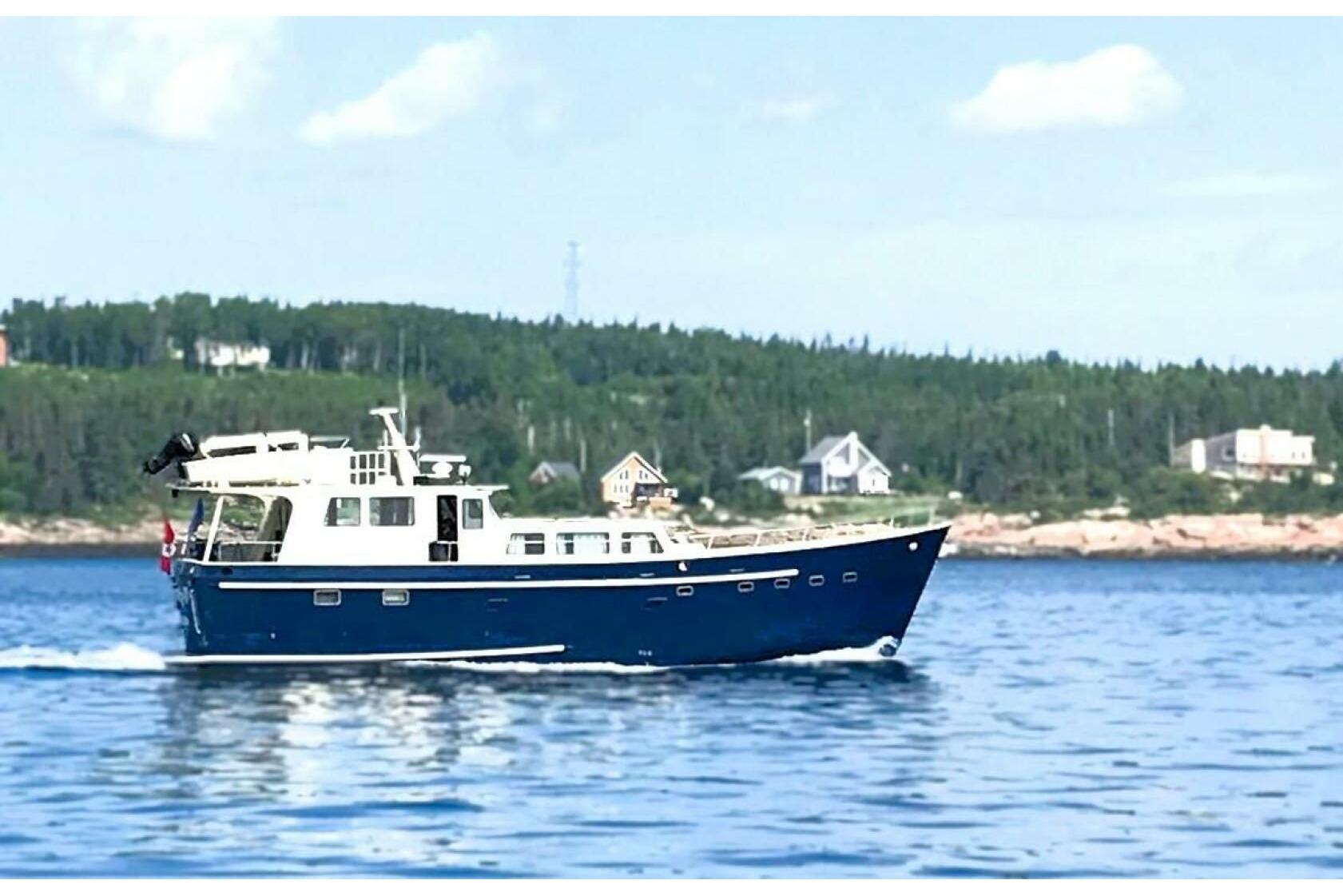 Custom Stubbs Aluminum 60' Trawler cruising on a scenic lake, 2017 model.