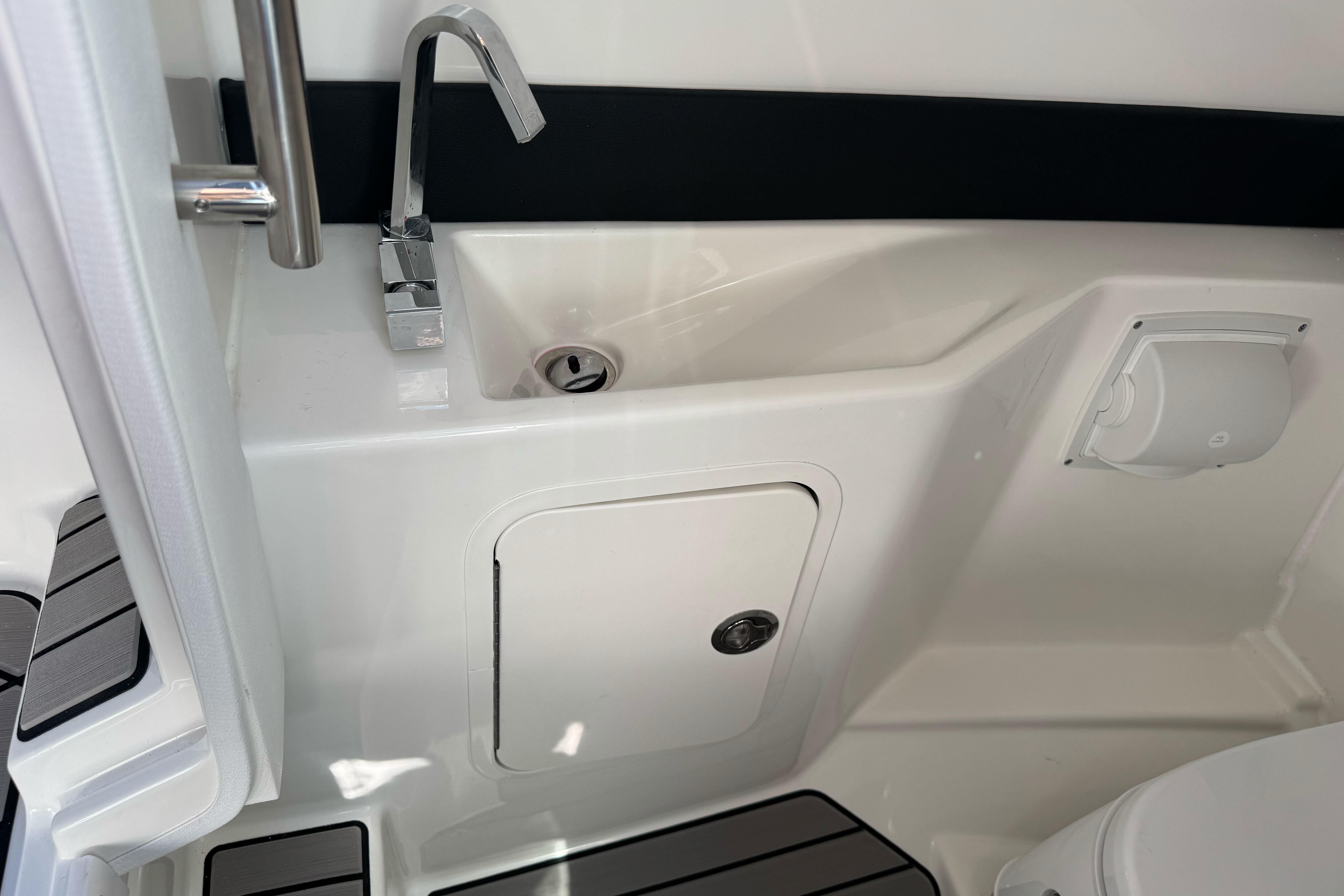 2026 Sea Ray SLX 260 boat interior with sink and storage compartment.