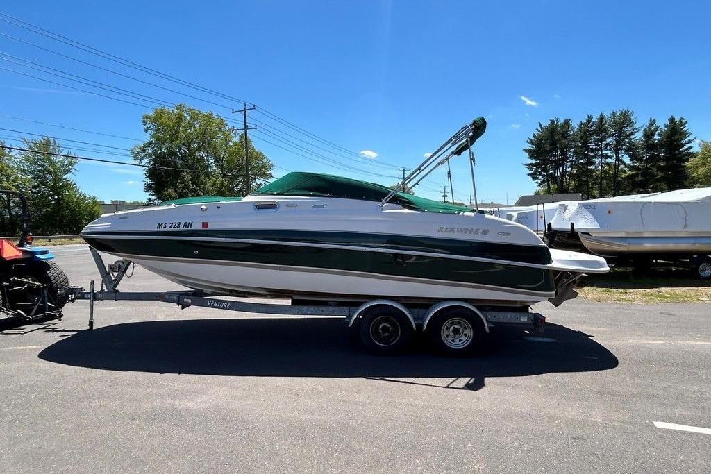 2006 Four Winns 244 Funship boat on trailer under clear blue sky.