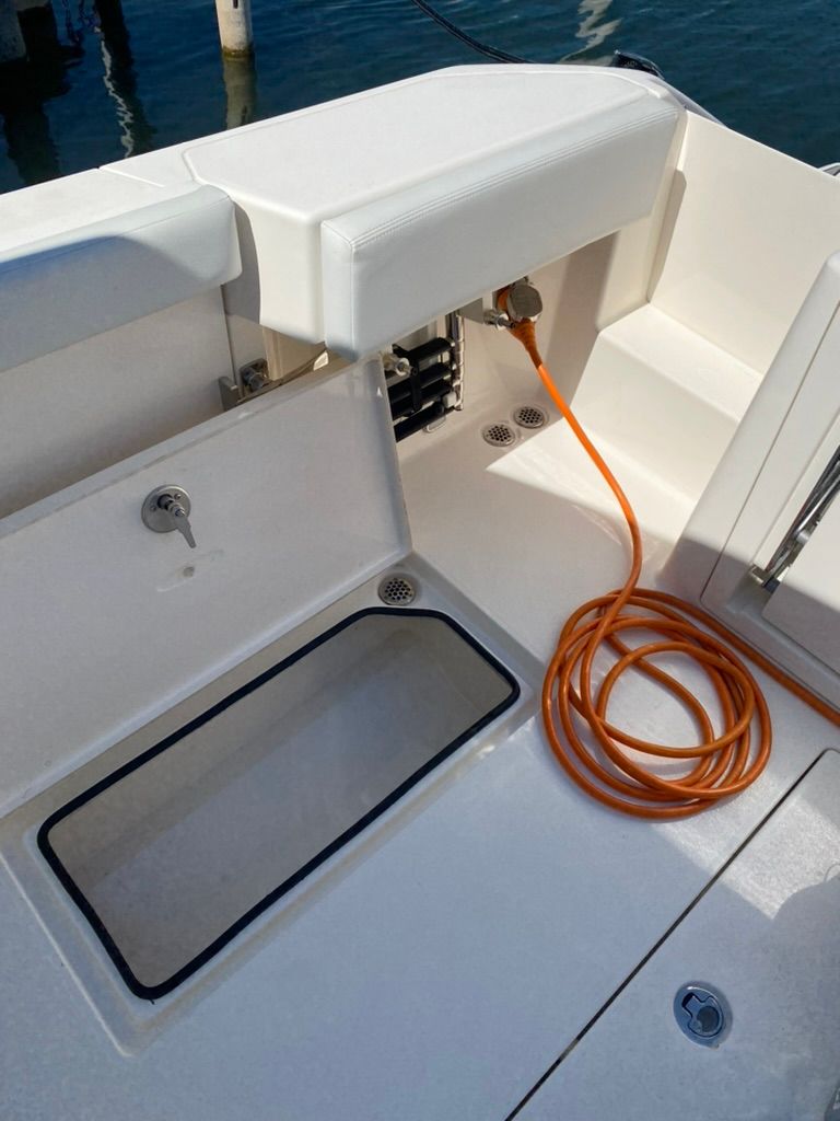 2023 Cobia 330 boat with storage compartment and cable.