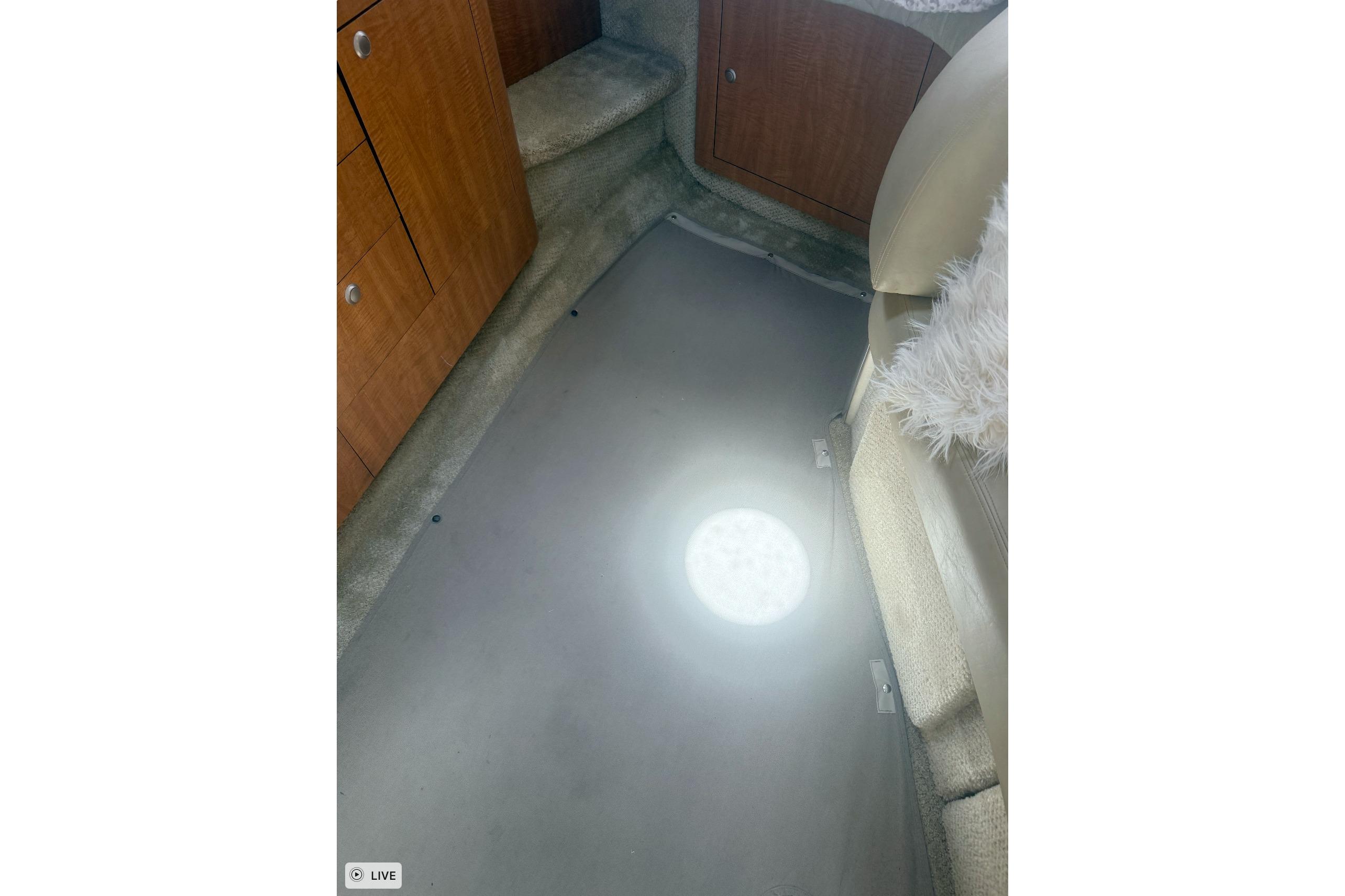 Interior of 2006 Sea Ray 300 Sundancer with wooden cabinets and plush seating.