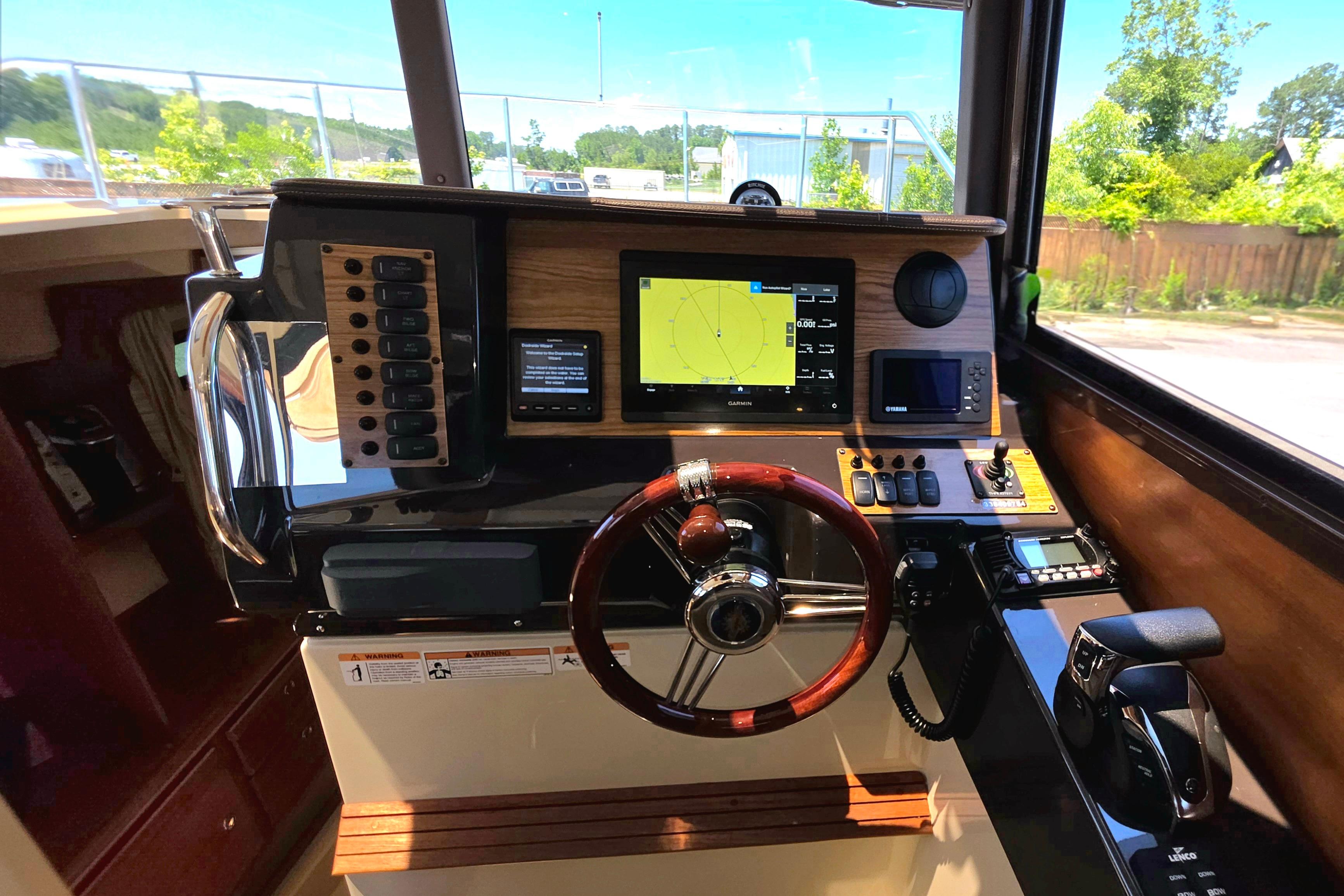 2021 Ranger Tug R27 helm with navigation controls and wooden steering wheel.