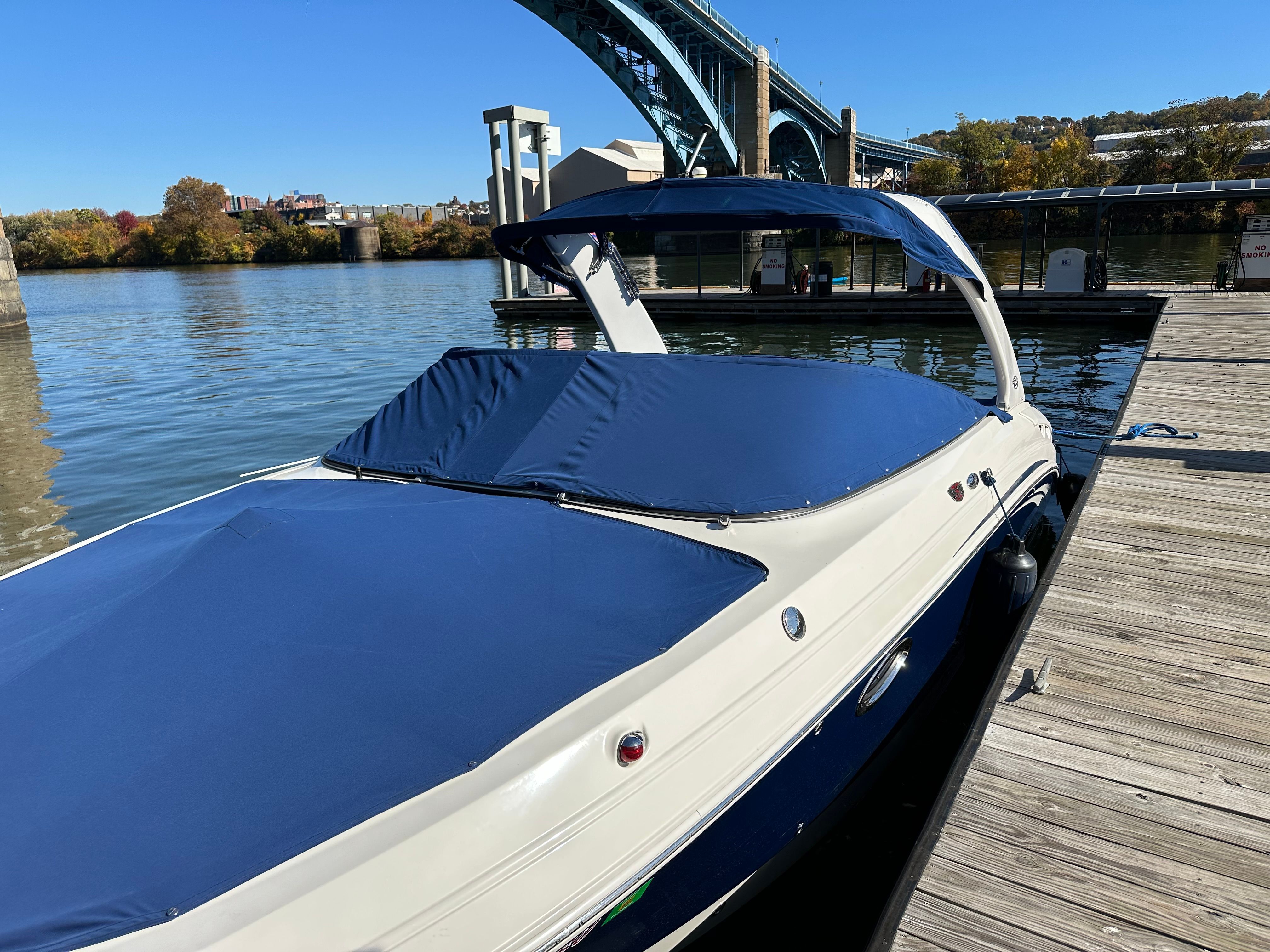 A 2011 Chaparral 287 SSX docked, featuring a blue cover and sleek design.