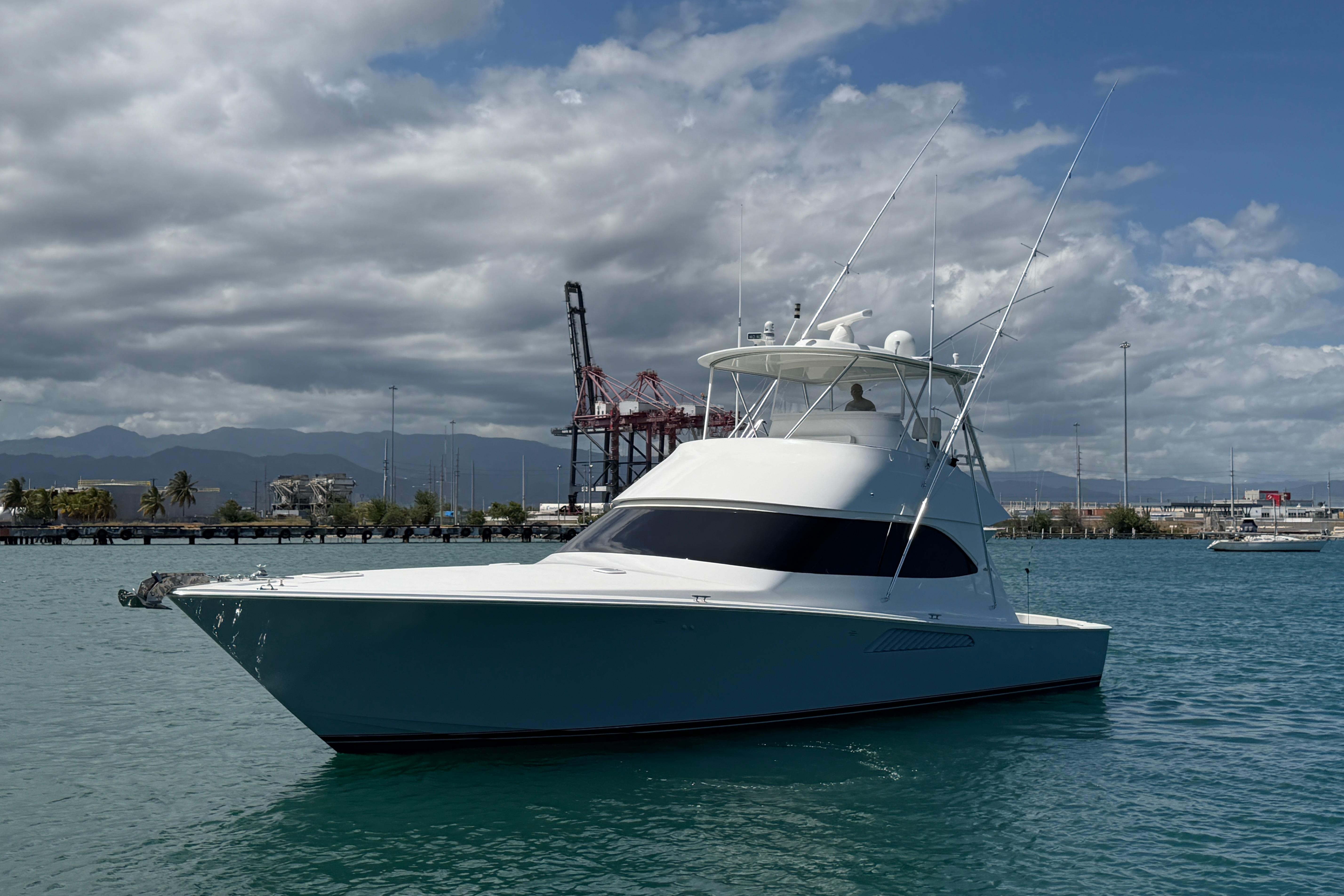 2012 Viking 50 Convertible yacht docked in a marina under cloudy skies.