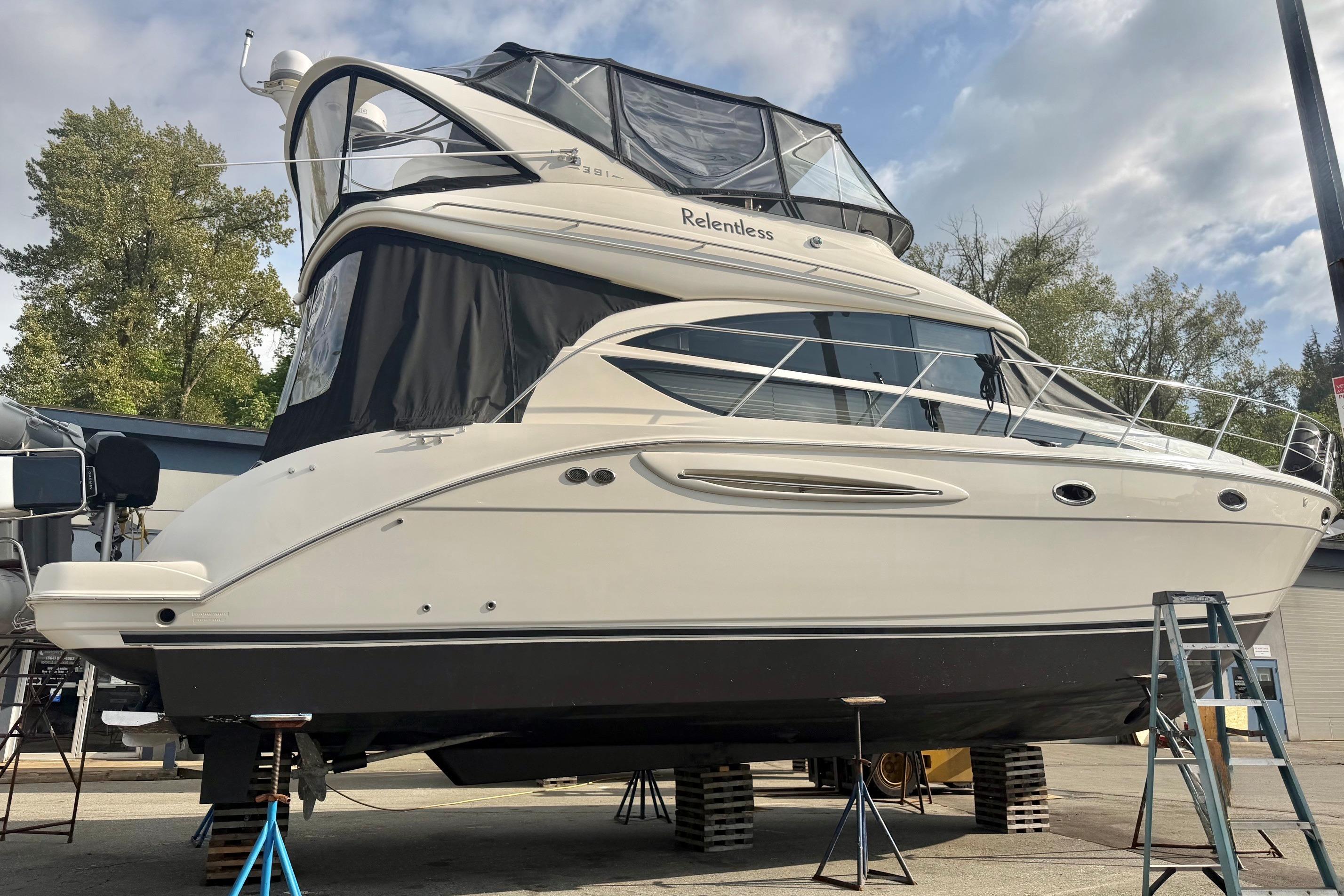 2007 Meridian 391 Sedan yacht on dry dock, surrounded by trees and equipment.