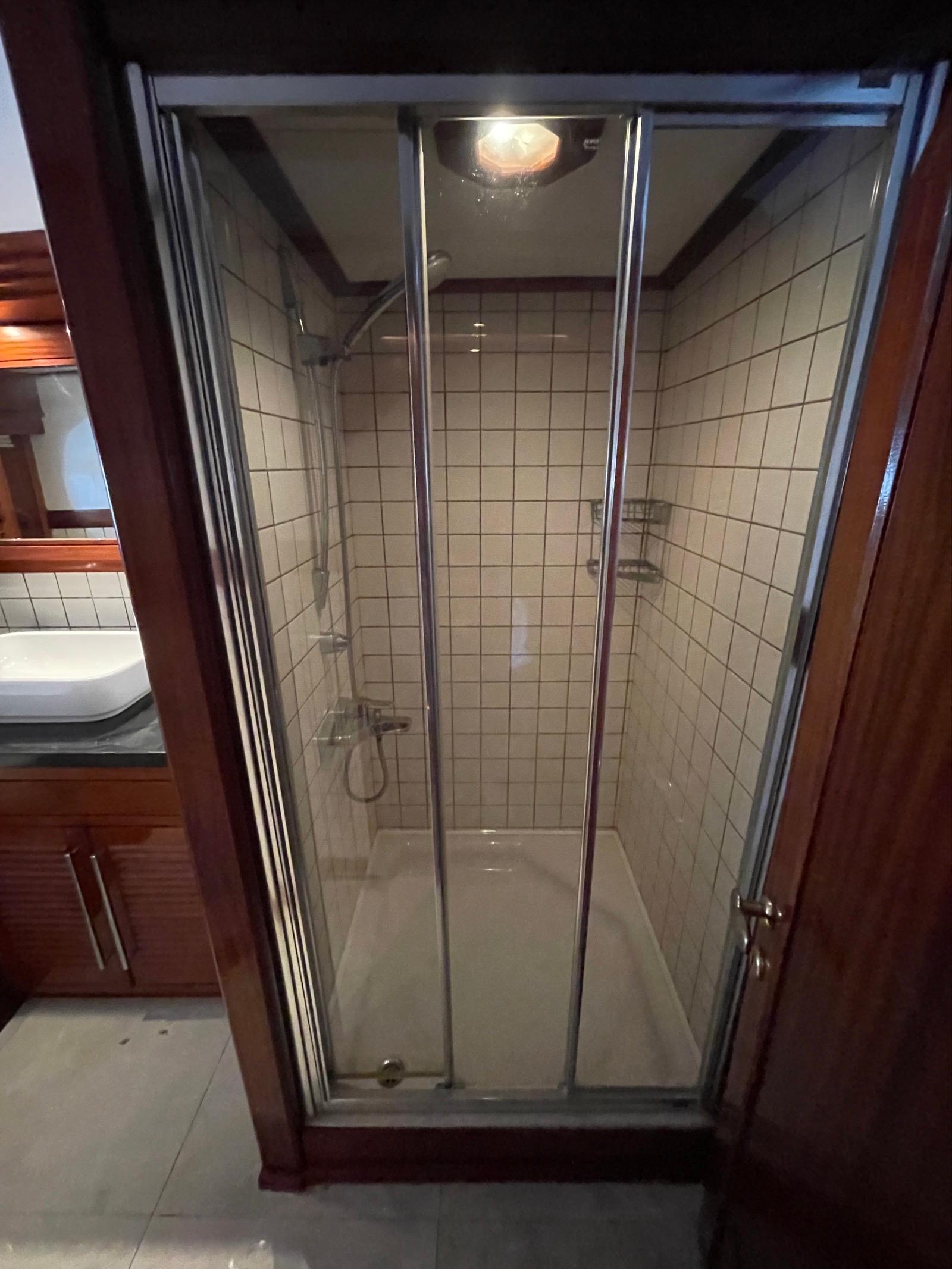 Shower cabin with glass doors in a 1999 Custom Classic Schooner bathroom.