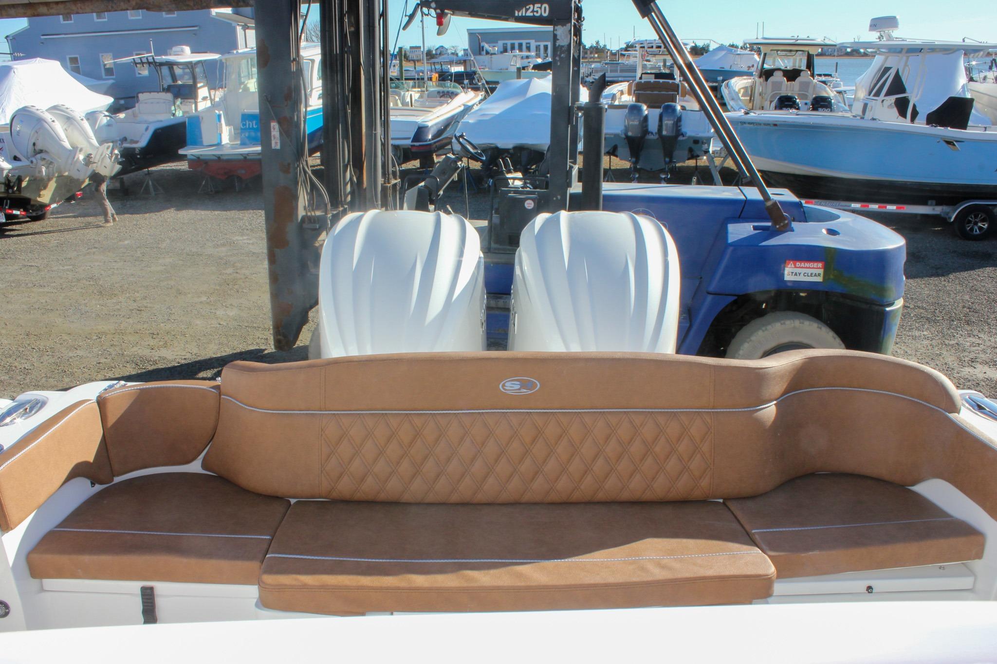 2026 Sea Hunt Ultra 285 SE boat with tan seating and dual engines in a marina setting.