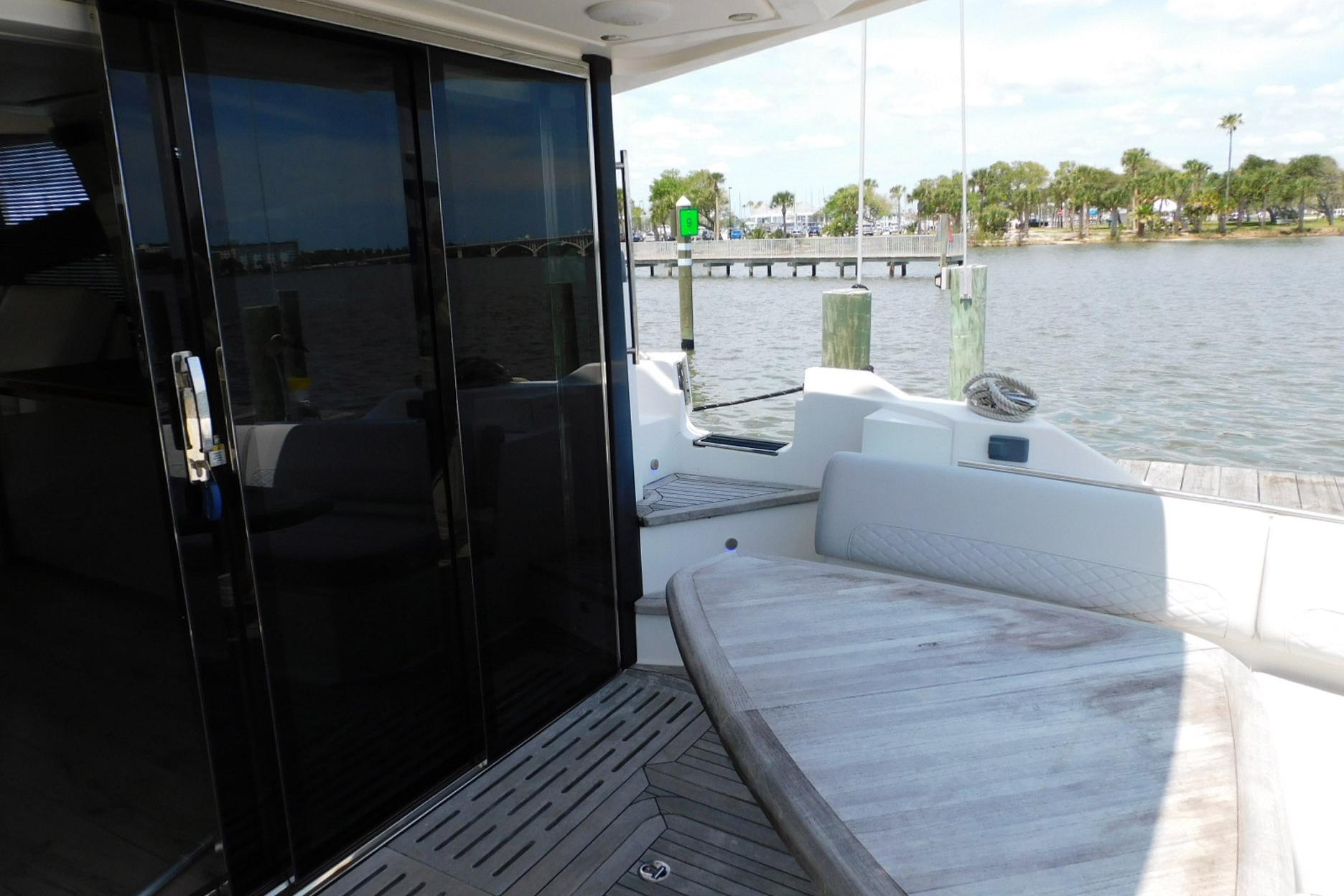 2019 Sea Ray L550 yacht deck with seating, overlooking a serene waterfront view.