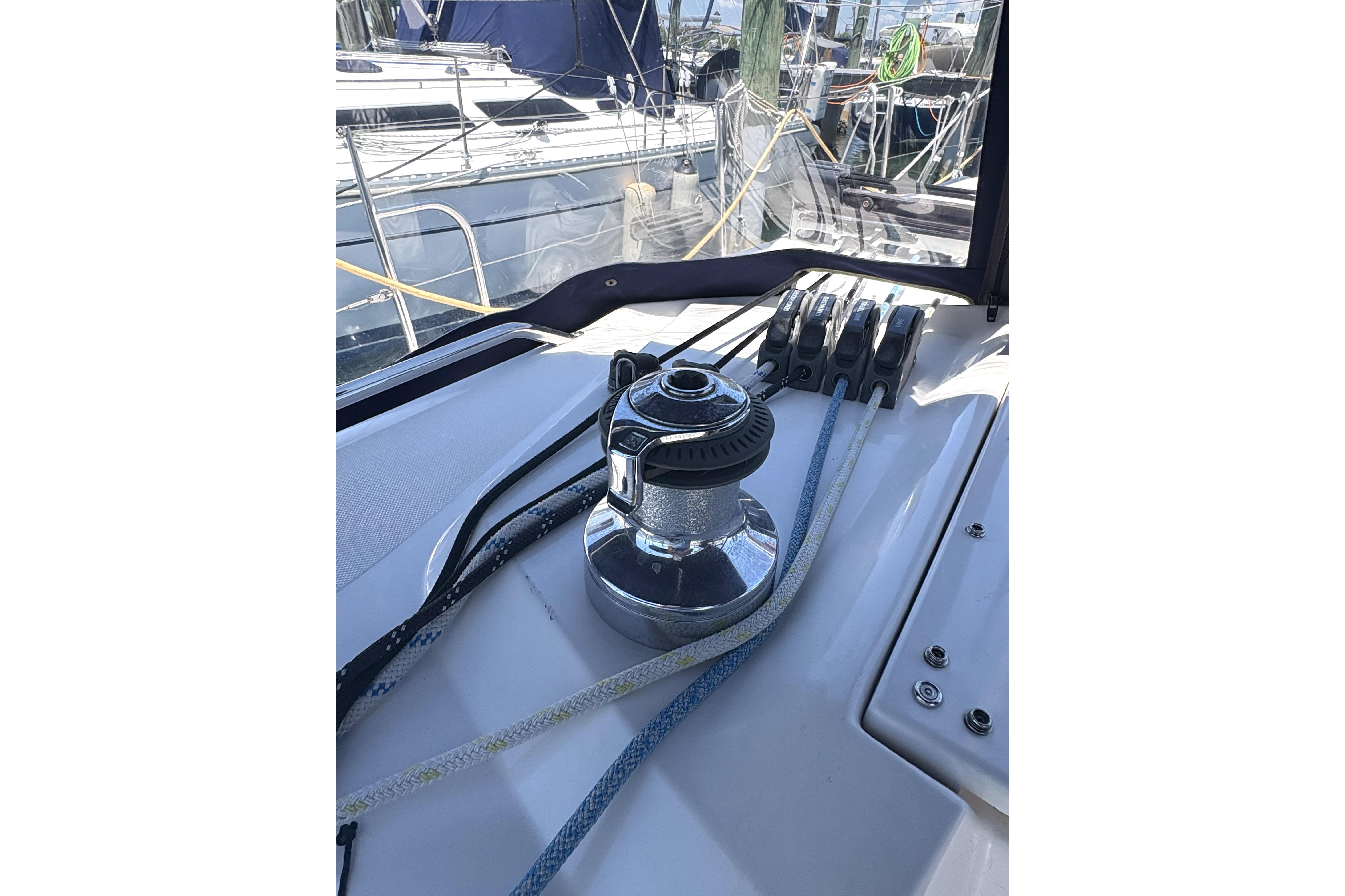 Winch and ropes on a 2011 Catalina 355 sailboat deck at a marina.