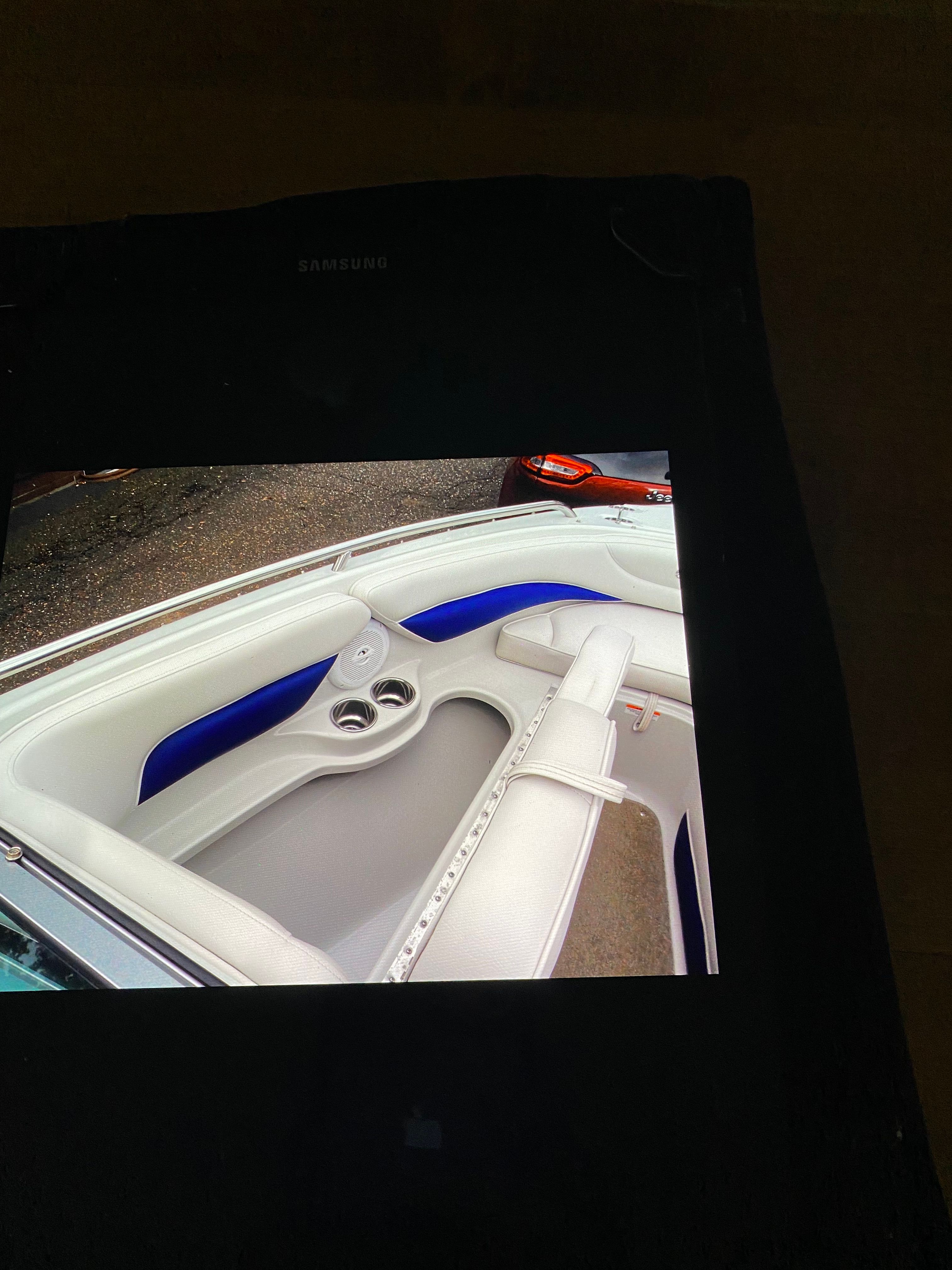 The image shows the bow area of a Crownline 21 bow rider with white and blue seating.