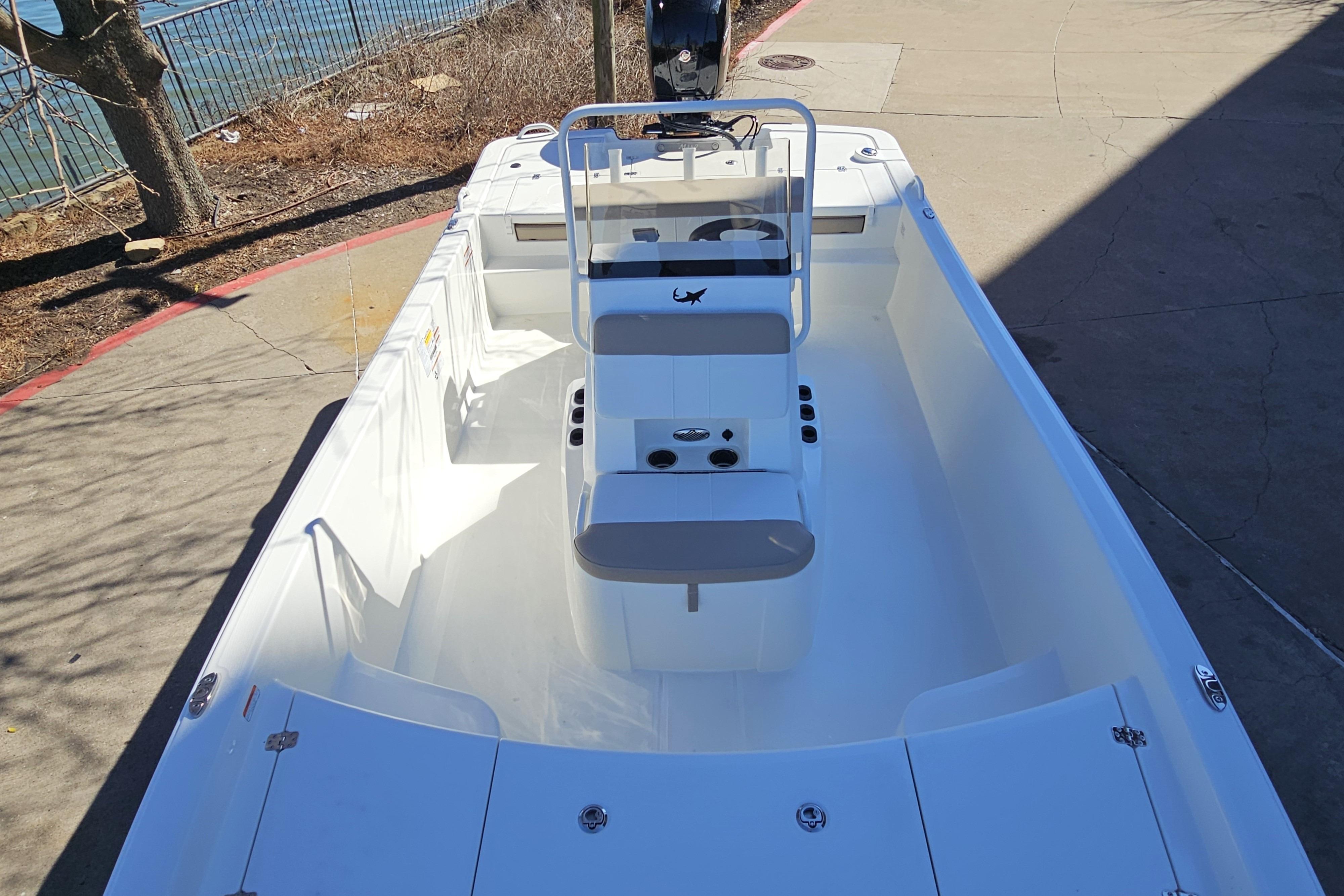 2026 Mako Pro Skiff 19 CC boat, white interior, center console, docked near water.