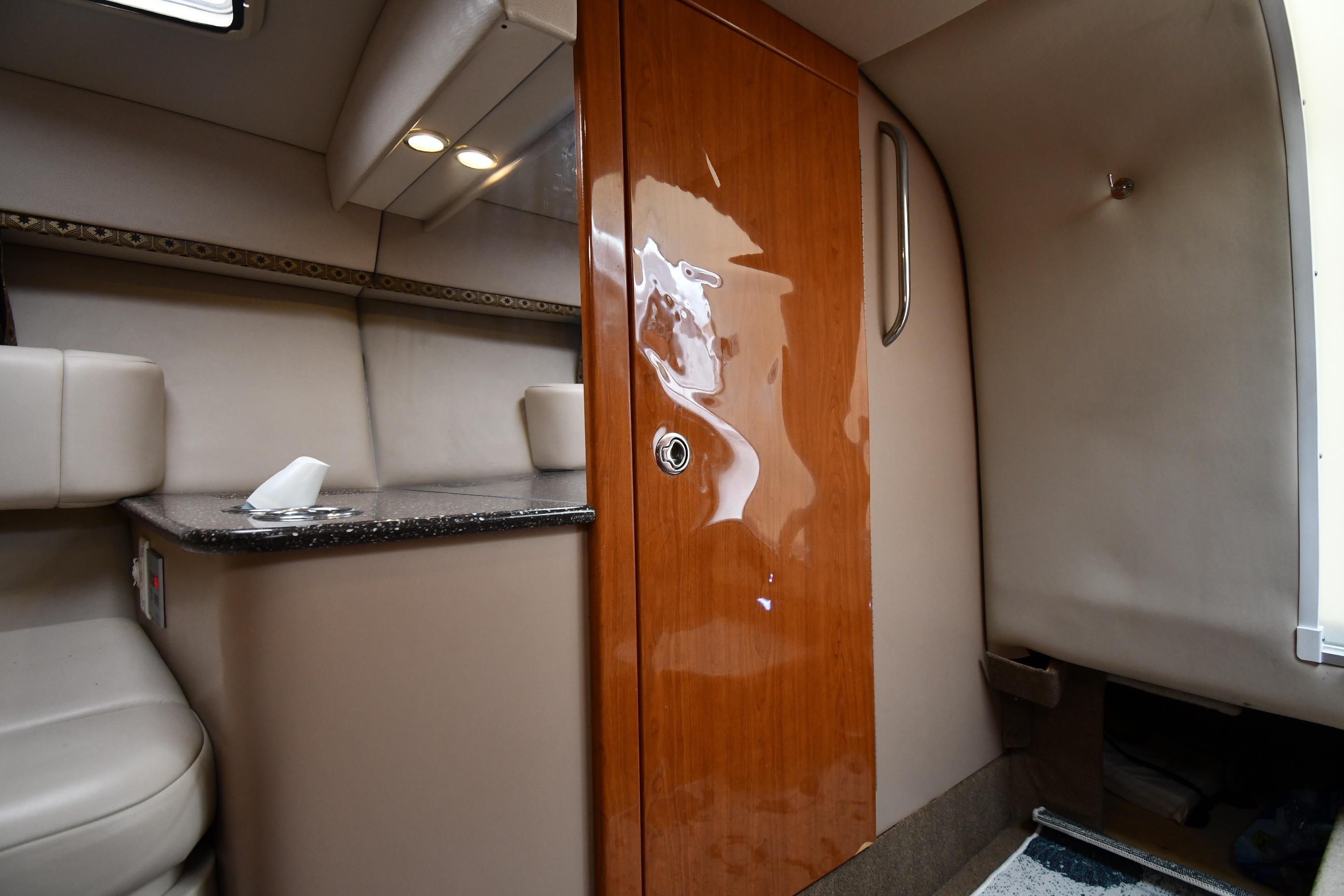 Interior of 2004 Formula 330 Sun Sport boat with wood door and seating area.