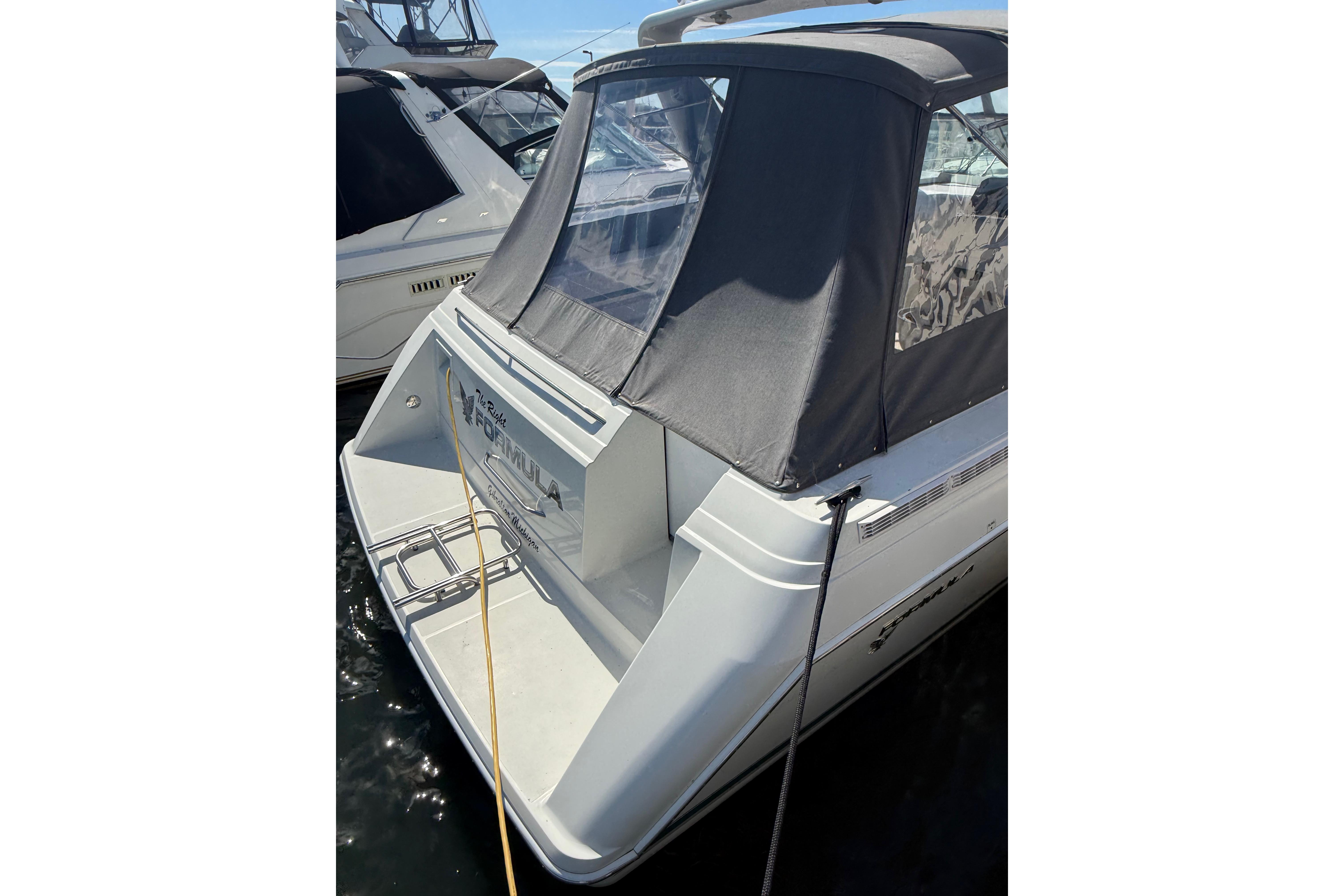 1999 Formula 34 Performance Cruiser docked, featuring a sleek design and covered cockpit.