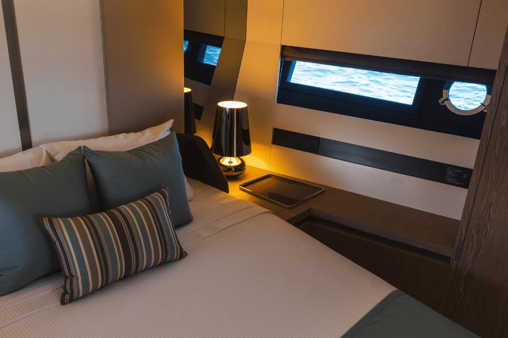 Luxurious bedroom interior of 2020 Azimut 60 yacht with ocean view windows.