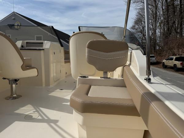 2025 Scout 215 Dorado boat interior with beige seating and helm, parked outdoors.