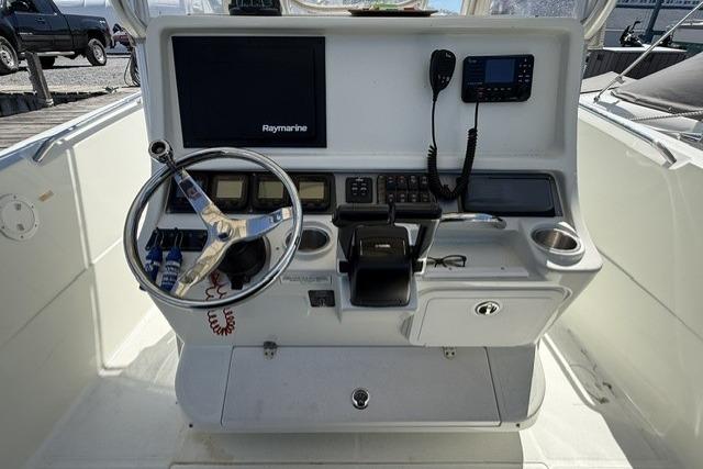 2006 Sailfish 2660 CC boat console with steering wheel, Raymarine display, and communication equipment.