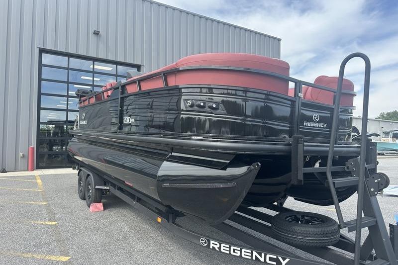 2026 Regency 230 DL pontoon boat on trailer outside a modern building.