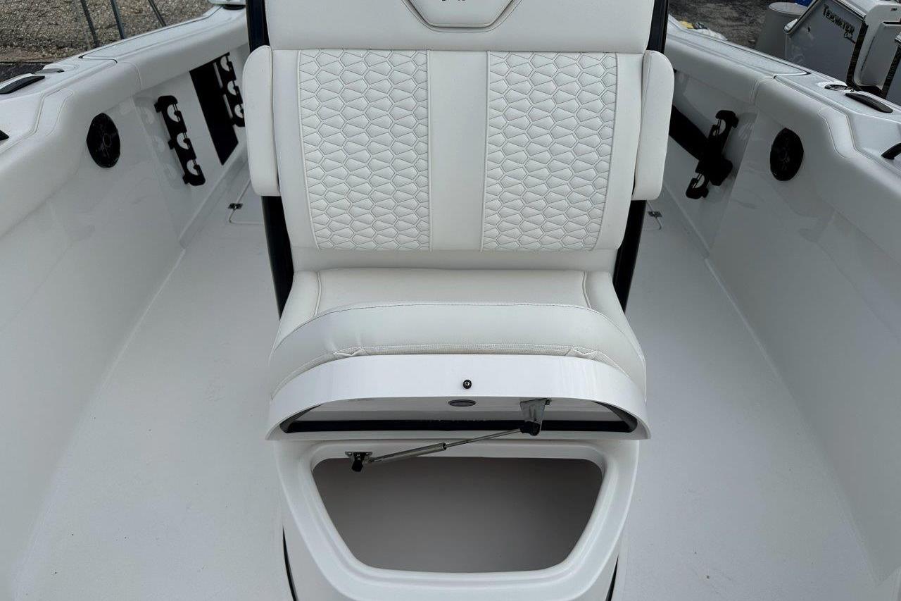 2026 Tidewater 272 LXF boat interior with white cushioned seating and storage compartment.