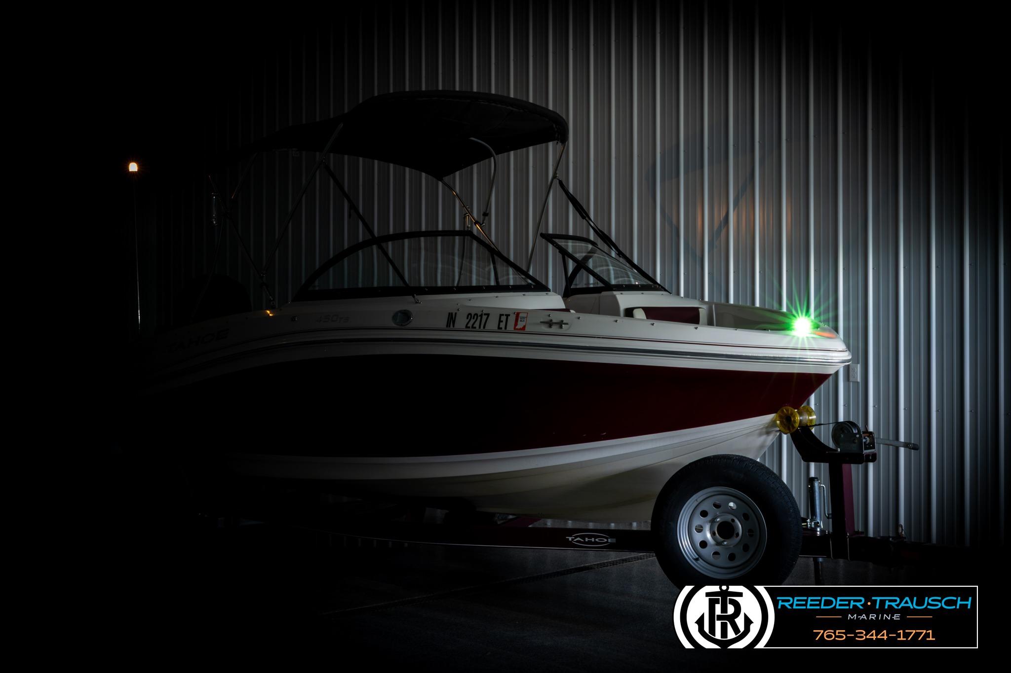 2016 Tahoe 450 TS boat in dimly lit garage with trailer.