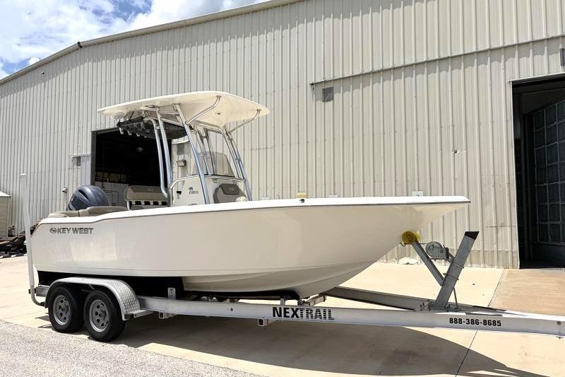2023 Key West 203 FS boat on trailer outside a large warehouse.