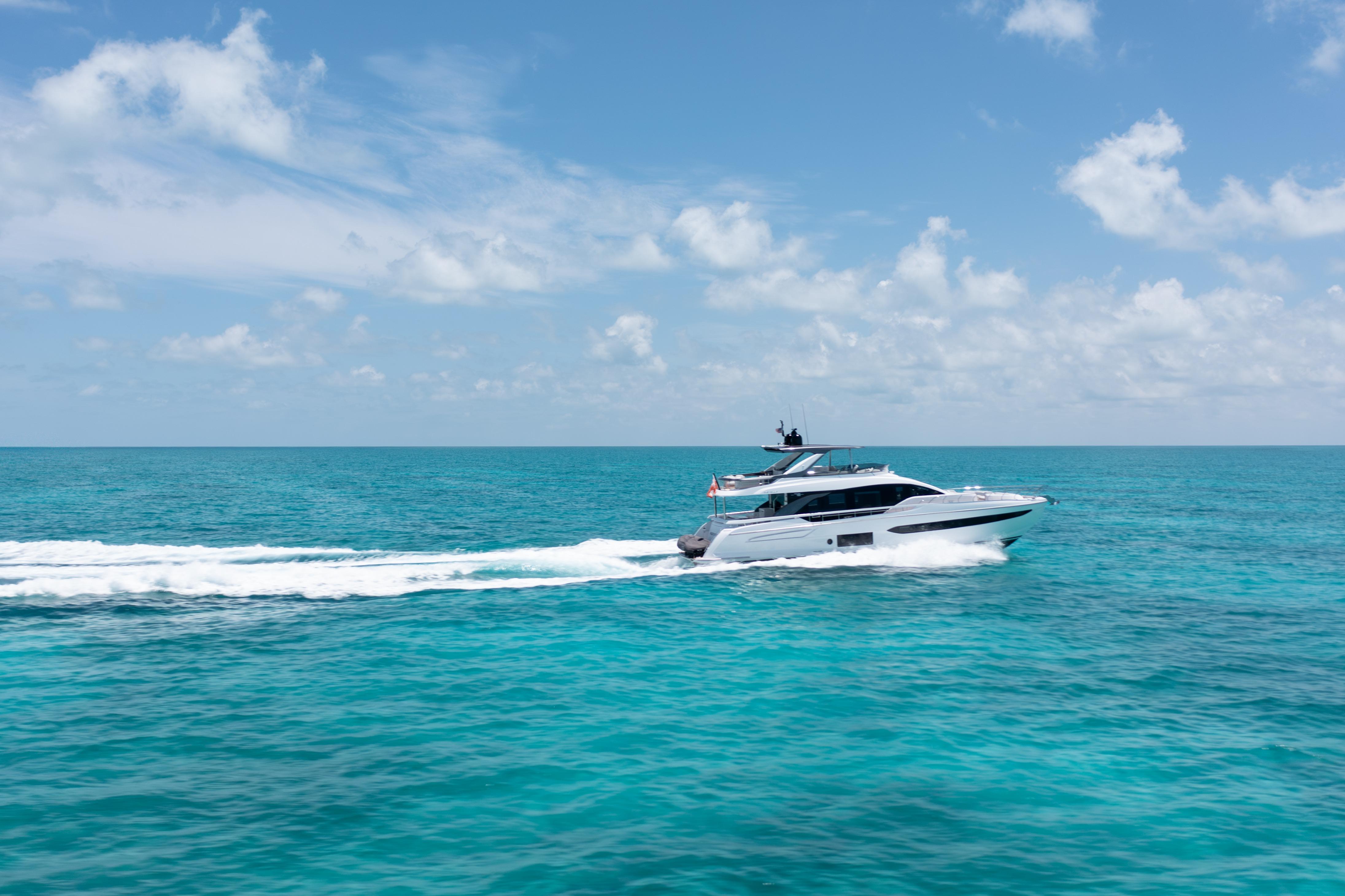 Luxury Azimut 78 yacht cruising on turquoise ocean under clear blue sky, 2022 model.