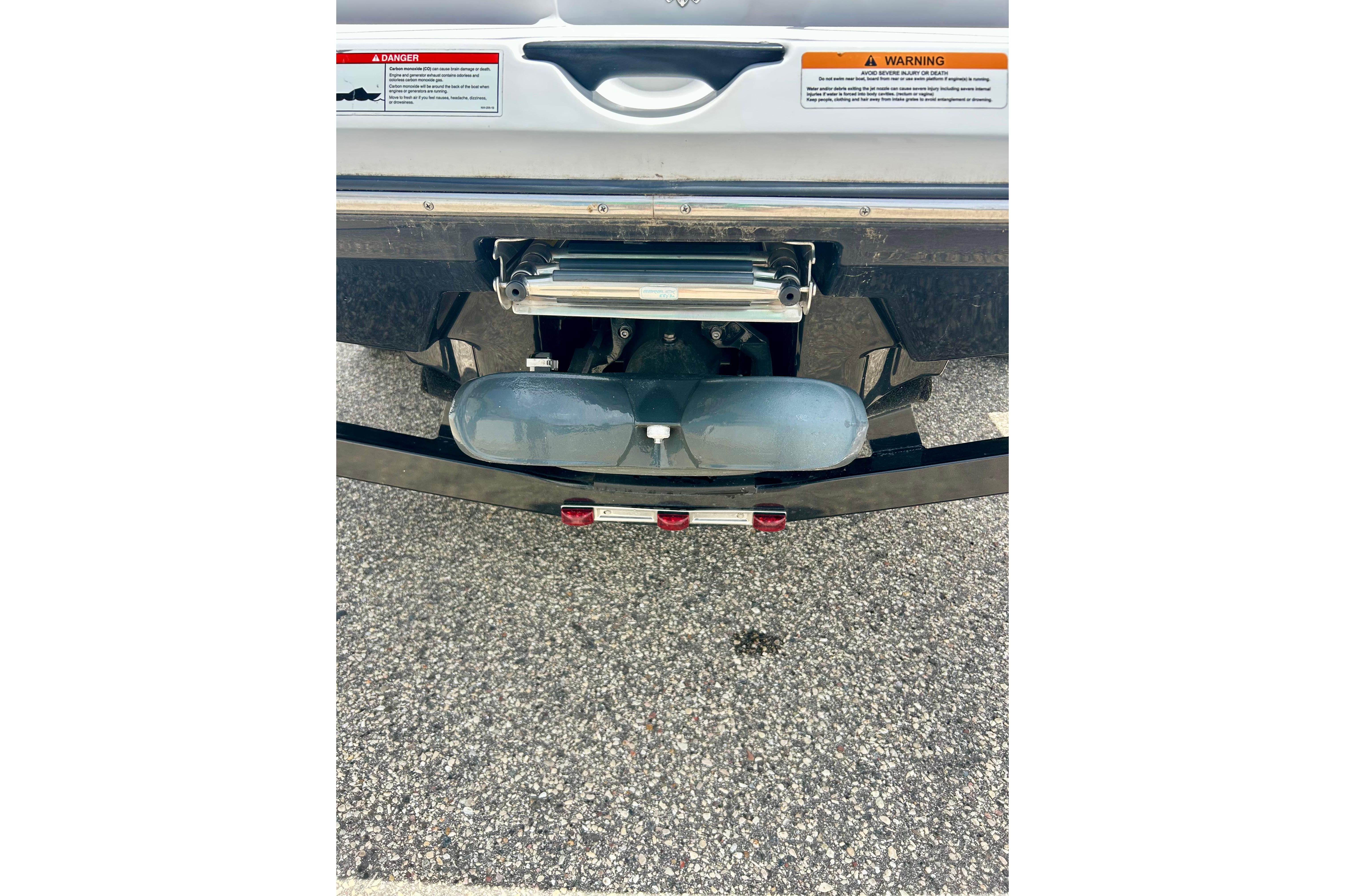 Rear view of a 2021 Scarab 195 ID boat with warning labels visible.