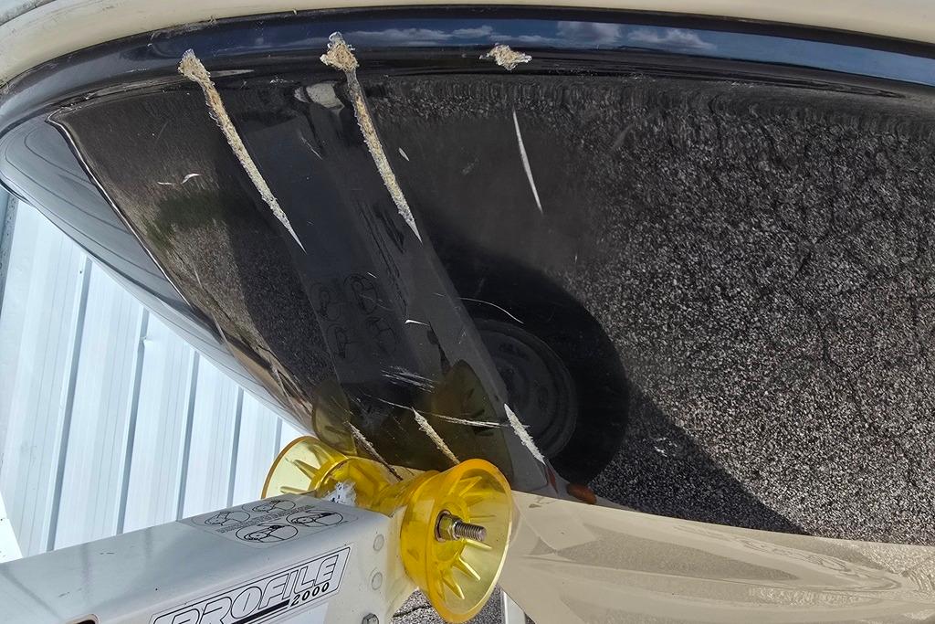 Damaged hull of a 2006 Sea Ray 185 Sport boat on a trailer.