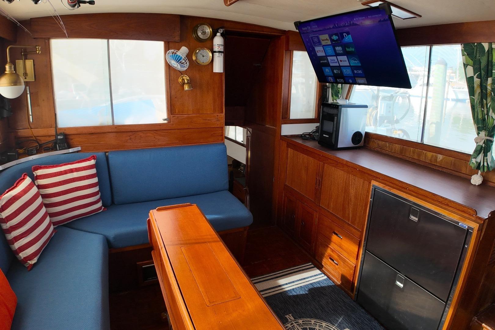 Interior of a 1978 Grand Banks 42 Classic yacht with blue seating and striped pillows.
