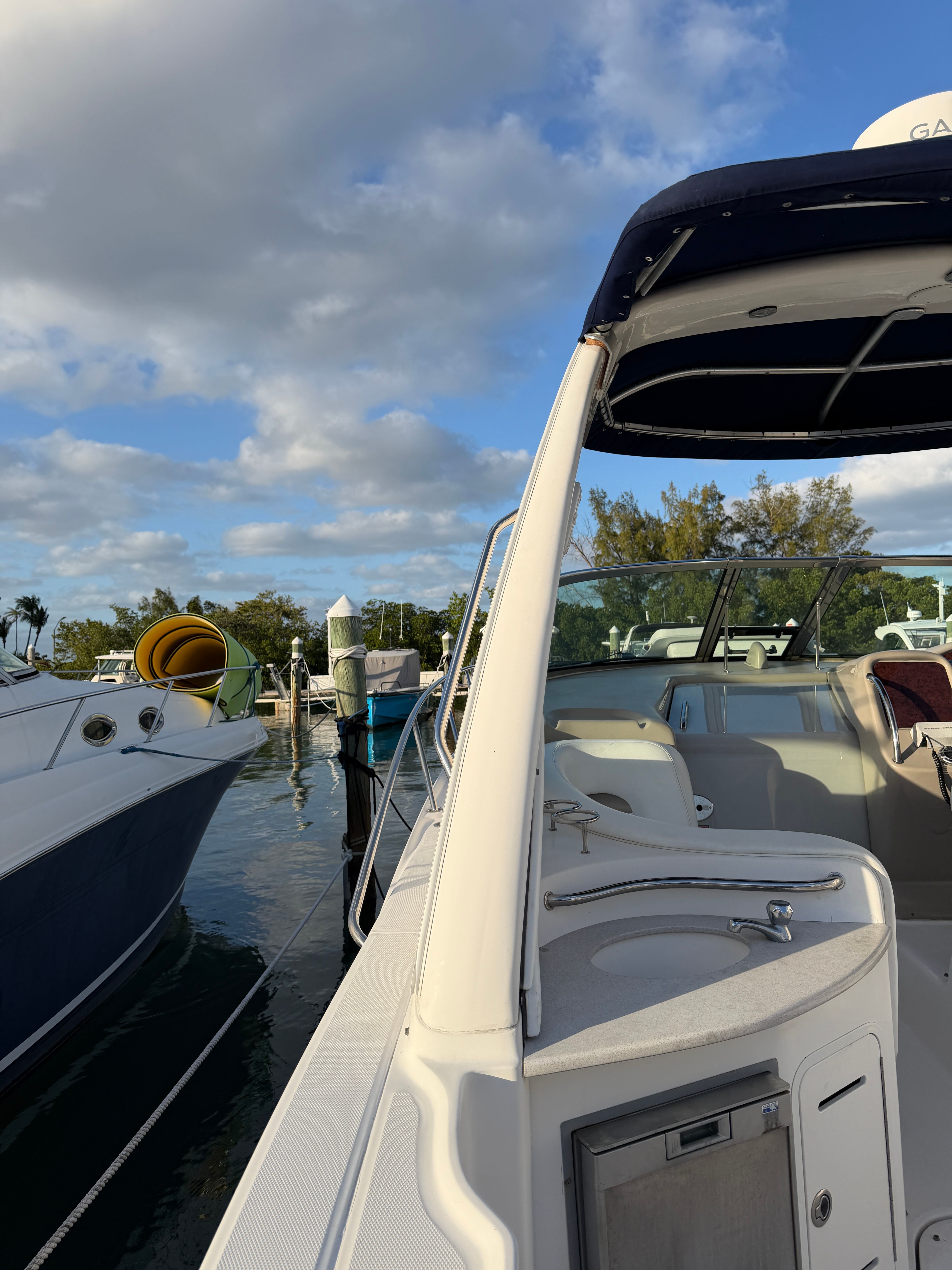 A 2006 Sea Ray Sundancer 320 docked. The sky is partly cloudy.