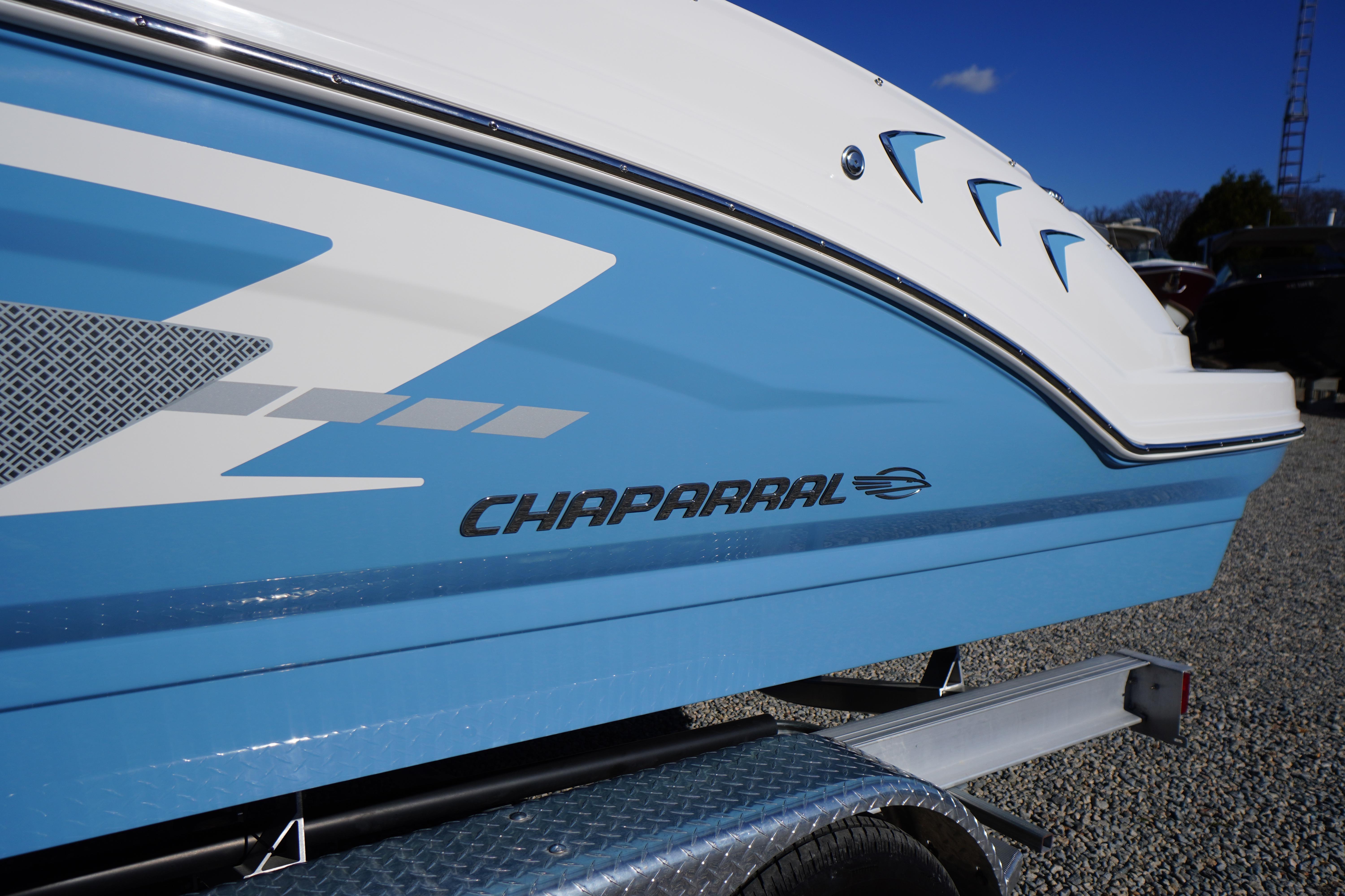 2026 Chaparral 23 SSi boat, blue and white design, side view on trailer.