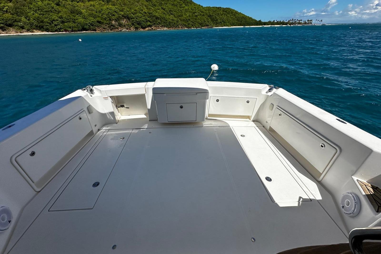 2012 Riviera 43 Flybridge boat deck with ocean view and lush green island backdrop.