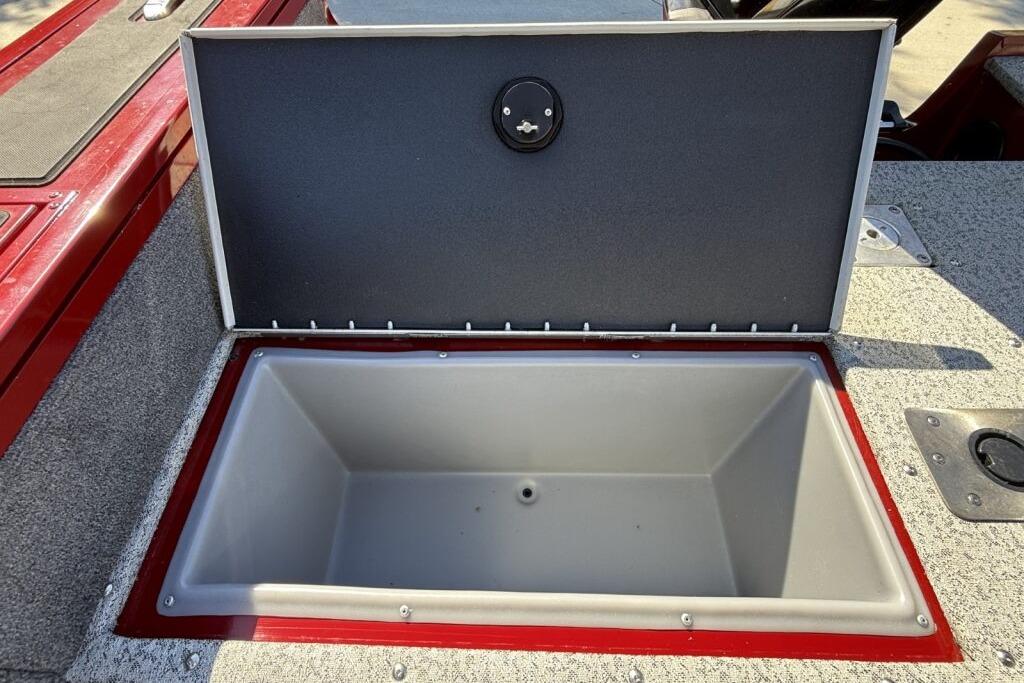 Open storage compartment on 2024 Tracker Targa V-19 WT boat, featuring red and gray interior.