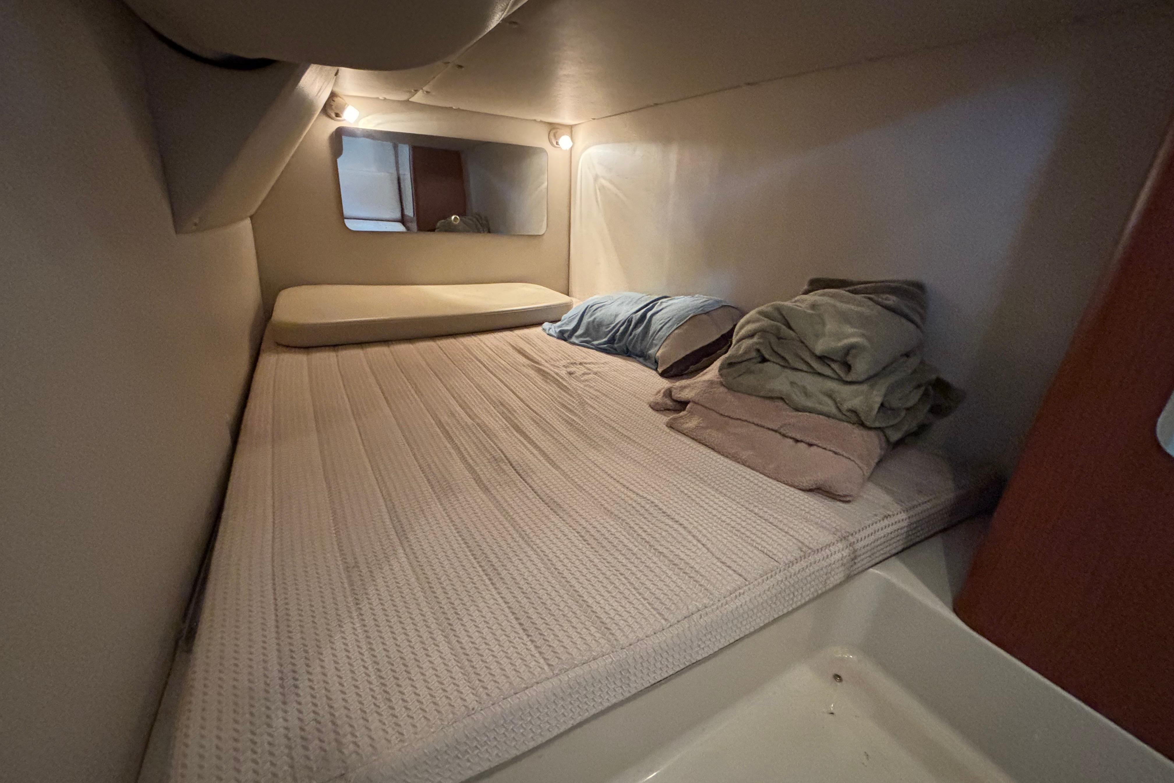 2004 Chaparral Signature 330 cabin interior with bed and folded linens.