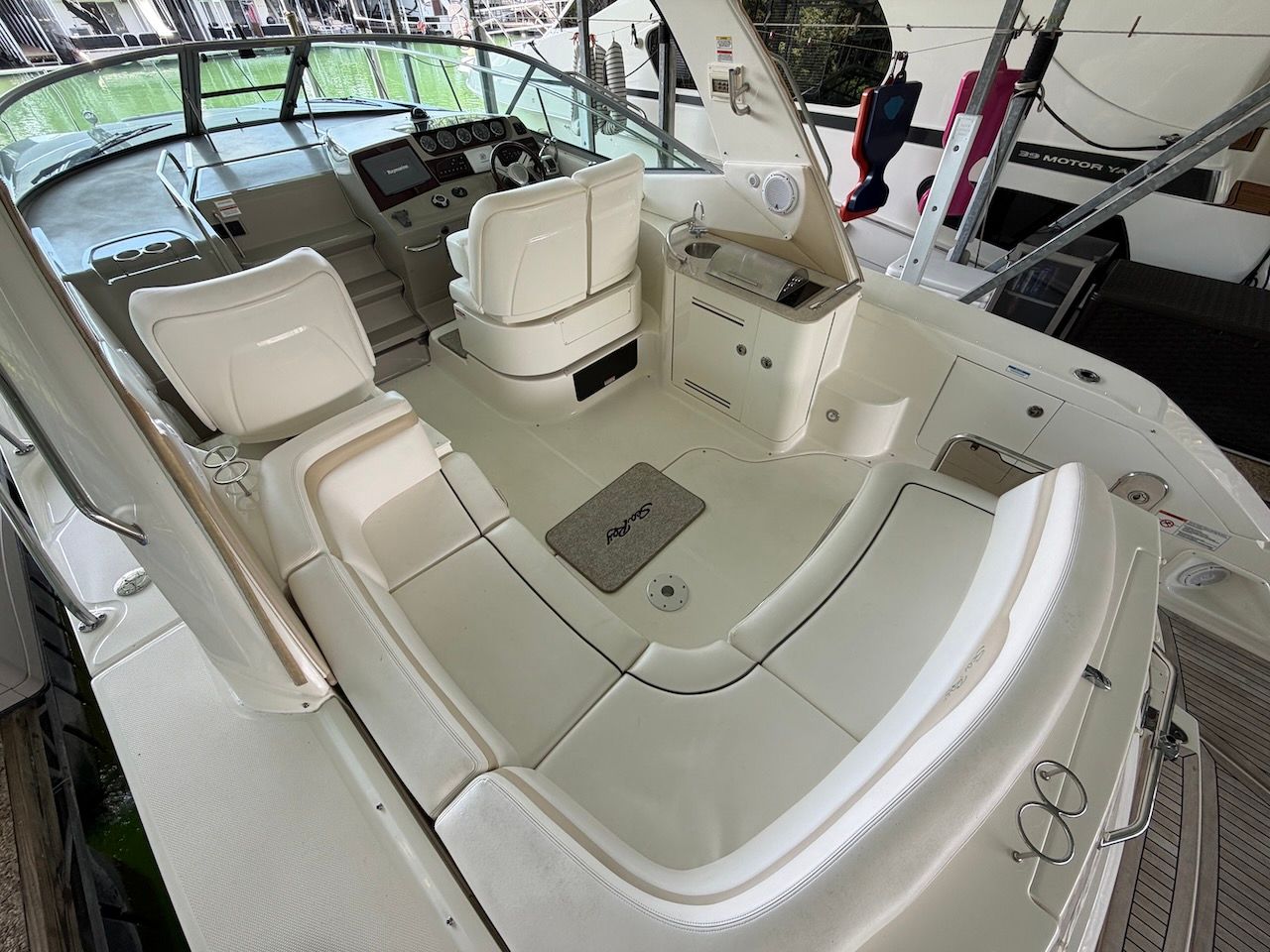 The image shows the cockpit of a 2011 Sea Ray Sundancer 370 with white seating.