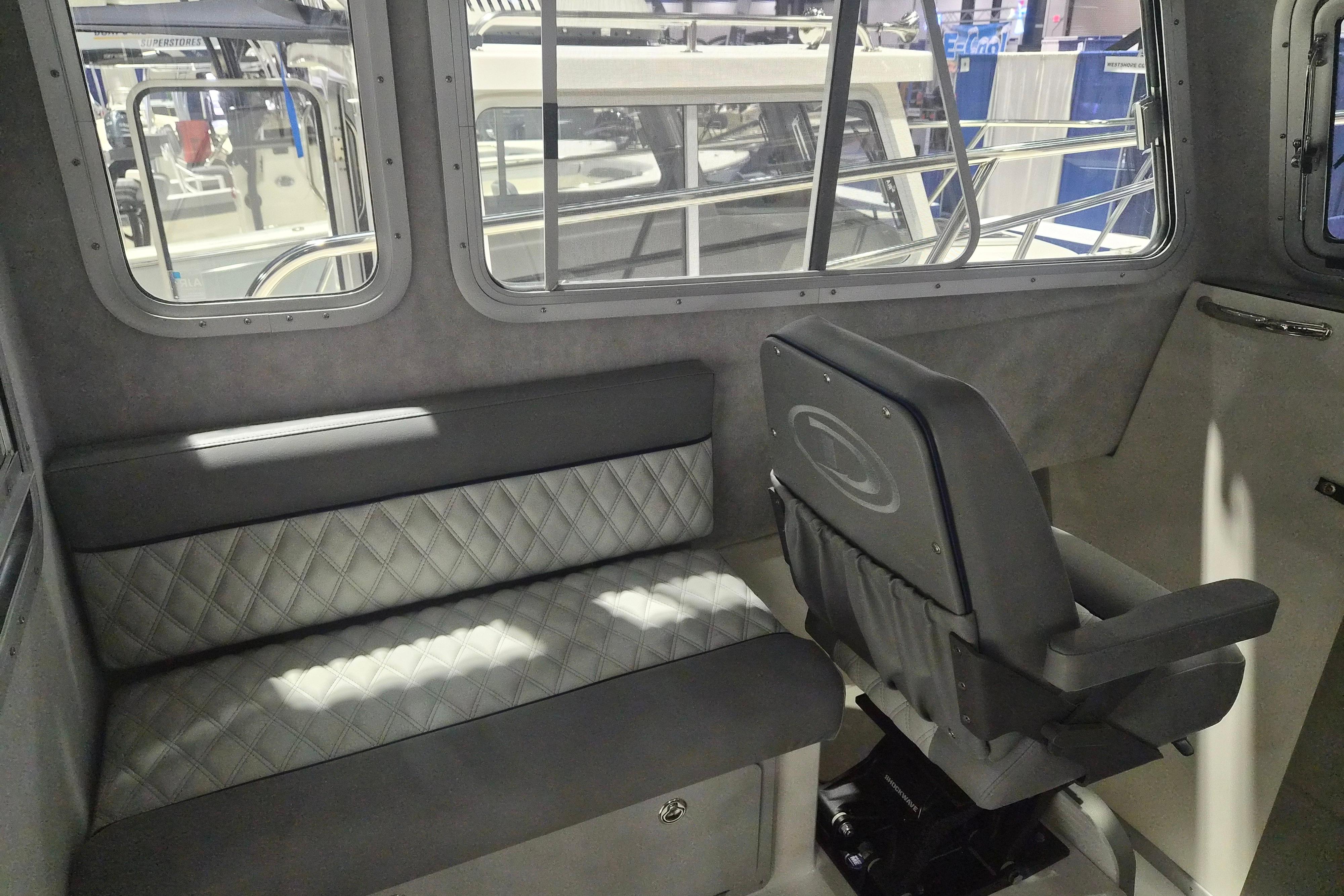 Interior of 2026 Defiance Admiral 260 EX boat with seating and windows.
