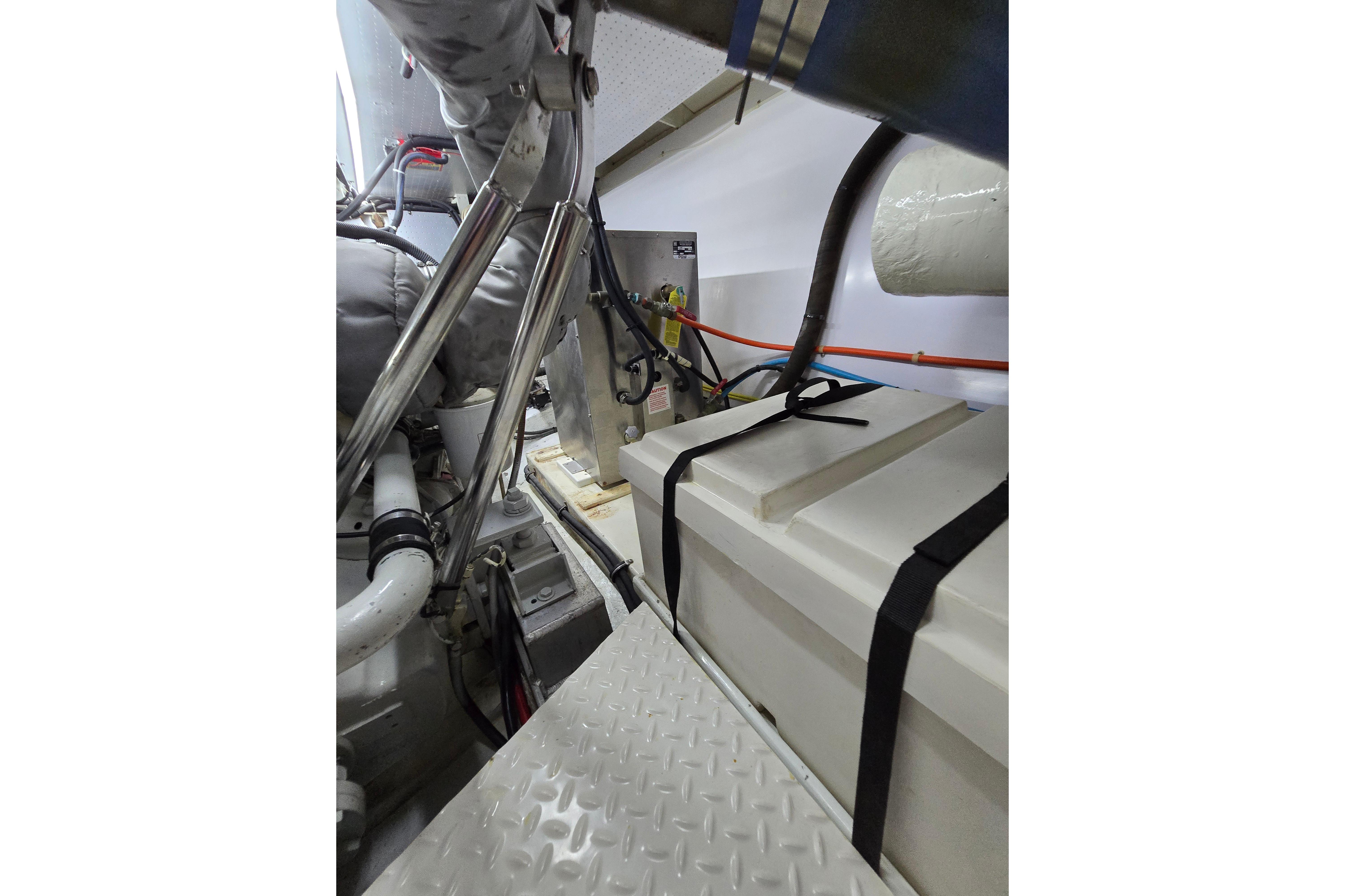 Engine room of 2004 Grand Harbour 58 yacht, featuring mechanical components and storage.