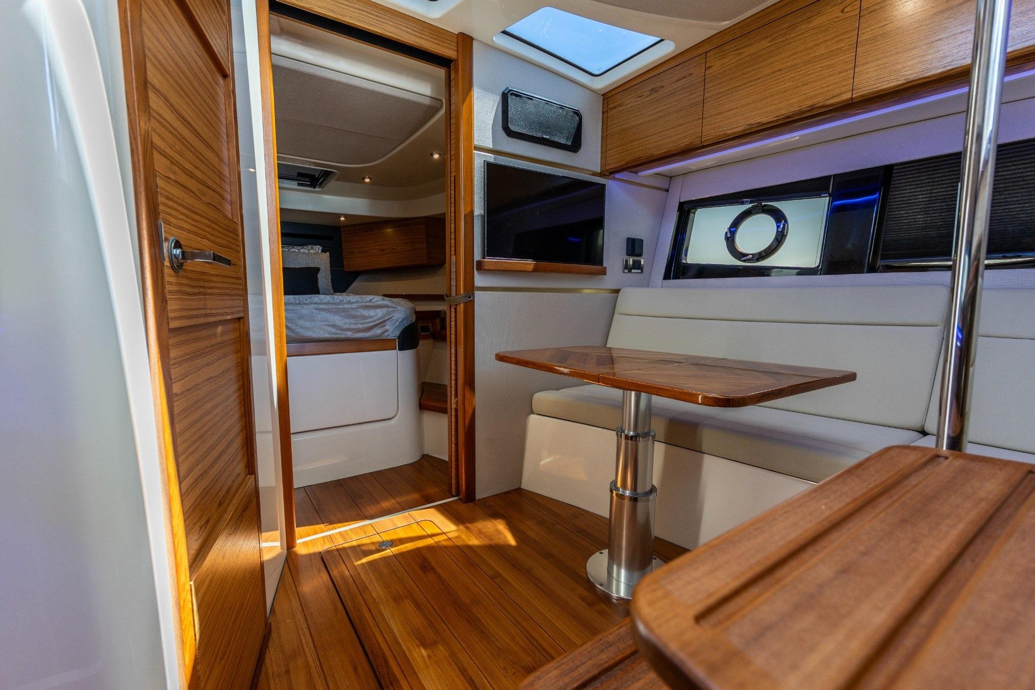 Luxurious interior of 2023 Boston Whaler 405 Conquest, featuring wood finishes and modern seating.