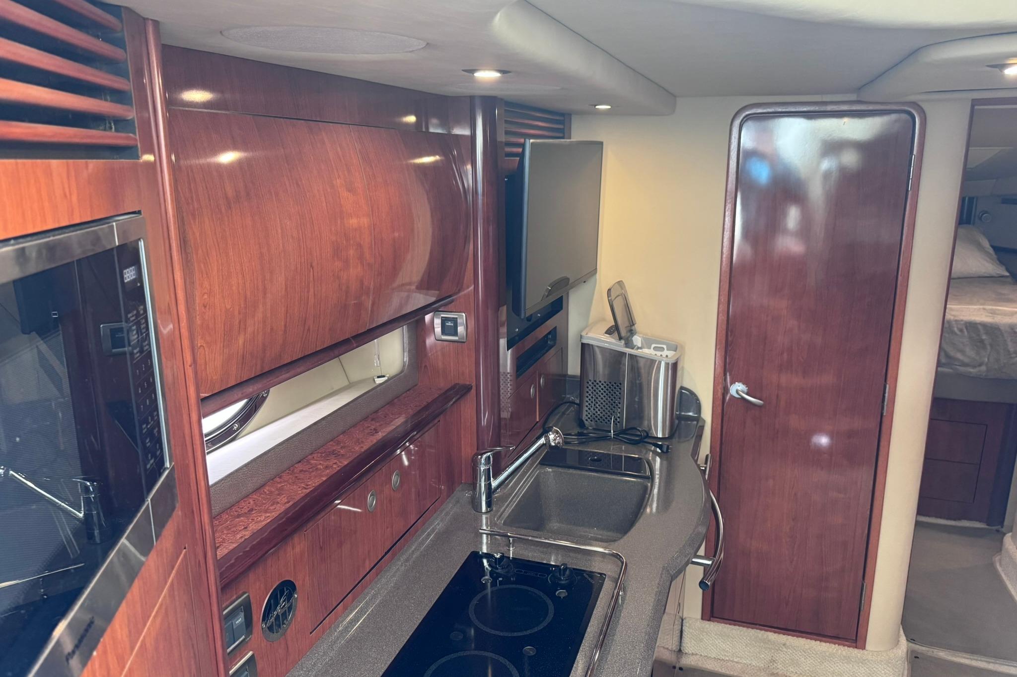 Interior of 2004 Sea Ray 390 Sundancer yacht with wood cabinetry and modern amenities.