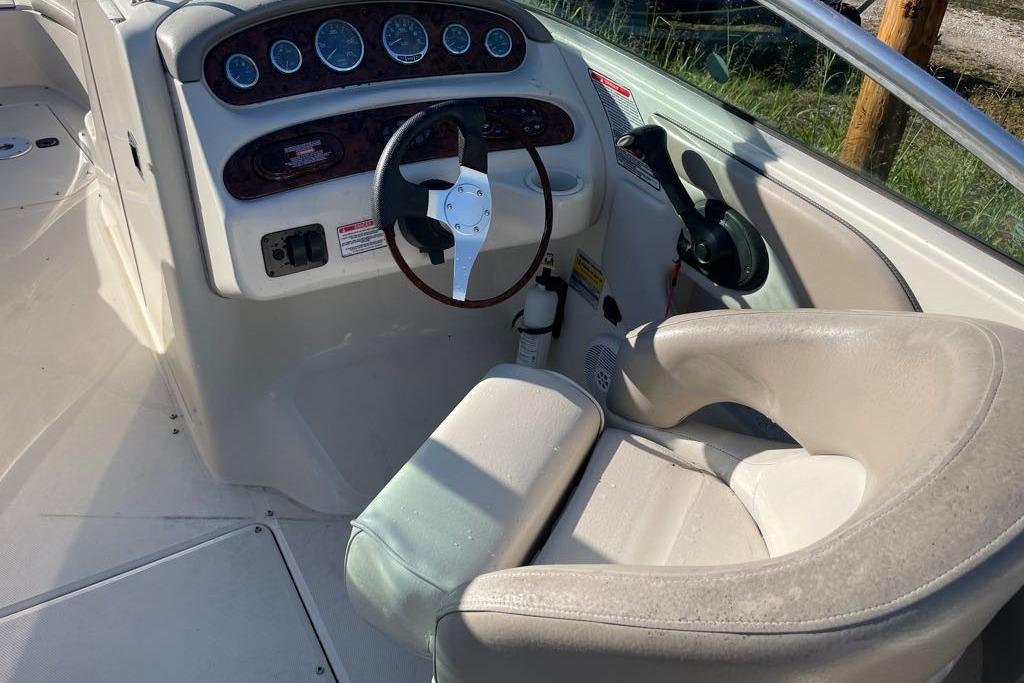 2004 Sea Ray 240 Sundeck boat cockpit with steering wheel and control panel.