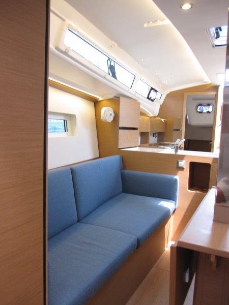 Interior of 2025 Jeanneau Sun Odyssey 350 yacht with blue seating and modern design.