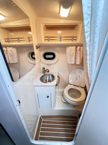 2015 Sea Ray 260 Sundancer bathroom with sink, toilet, and porthole window.