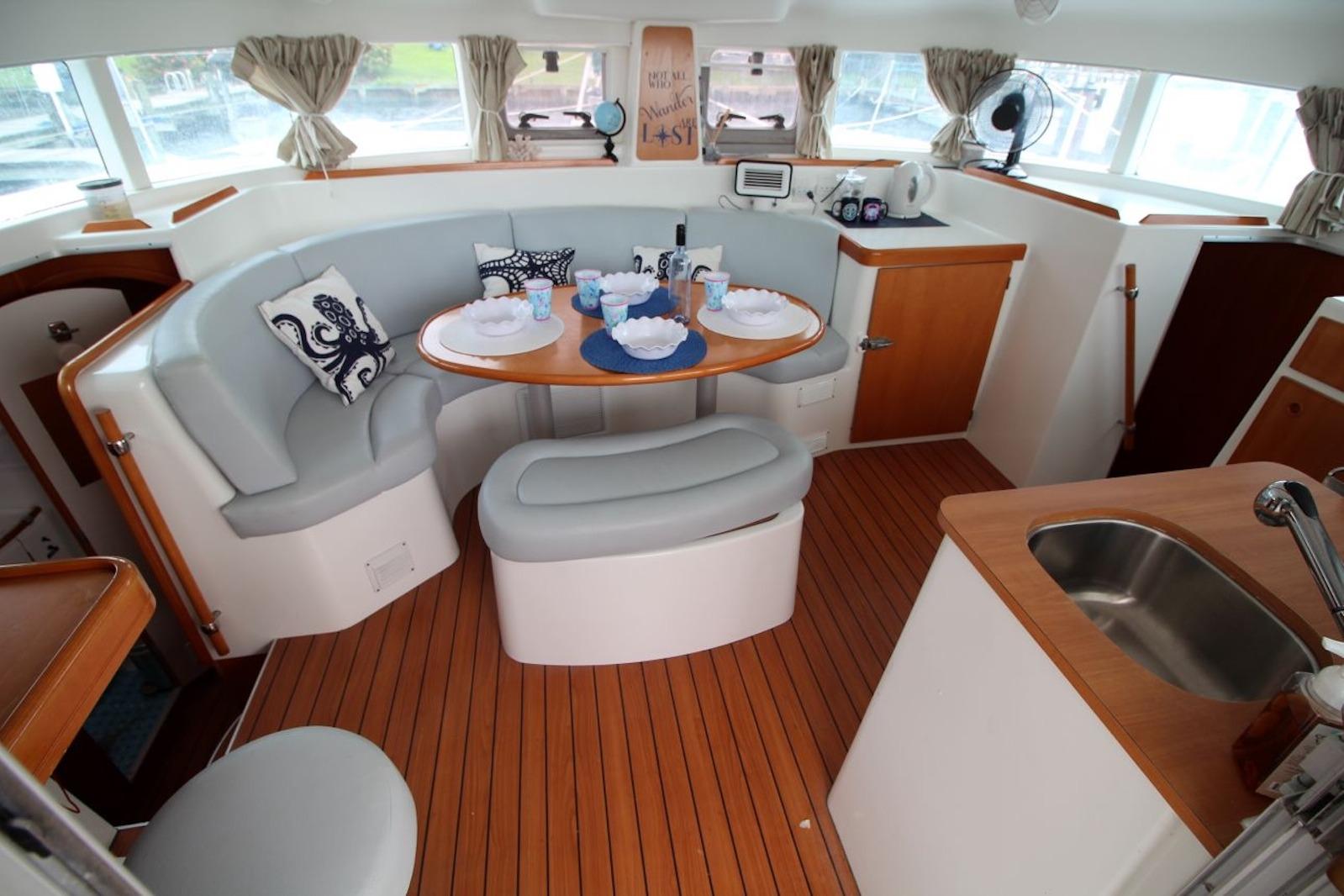 Interior of 2004 Lagoon 380 catamaran with cozy seating and dining area.