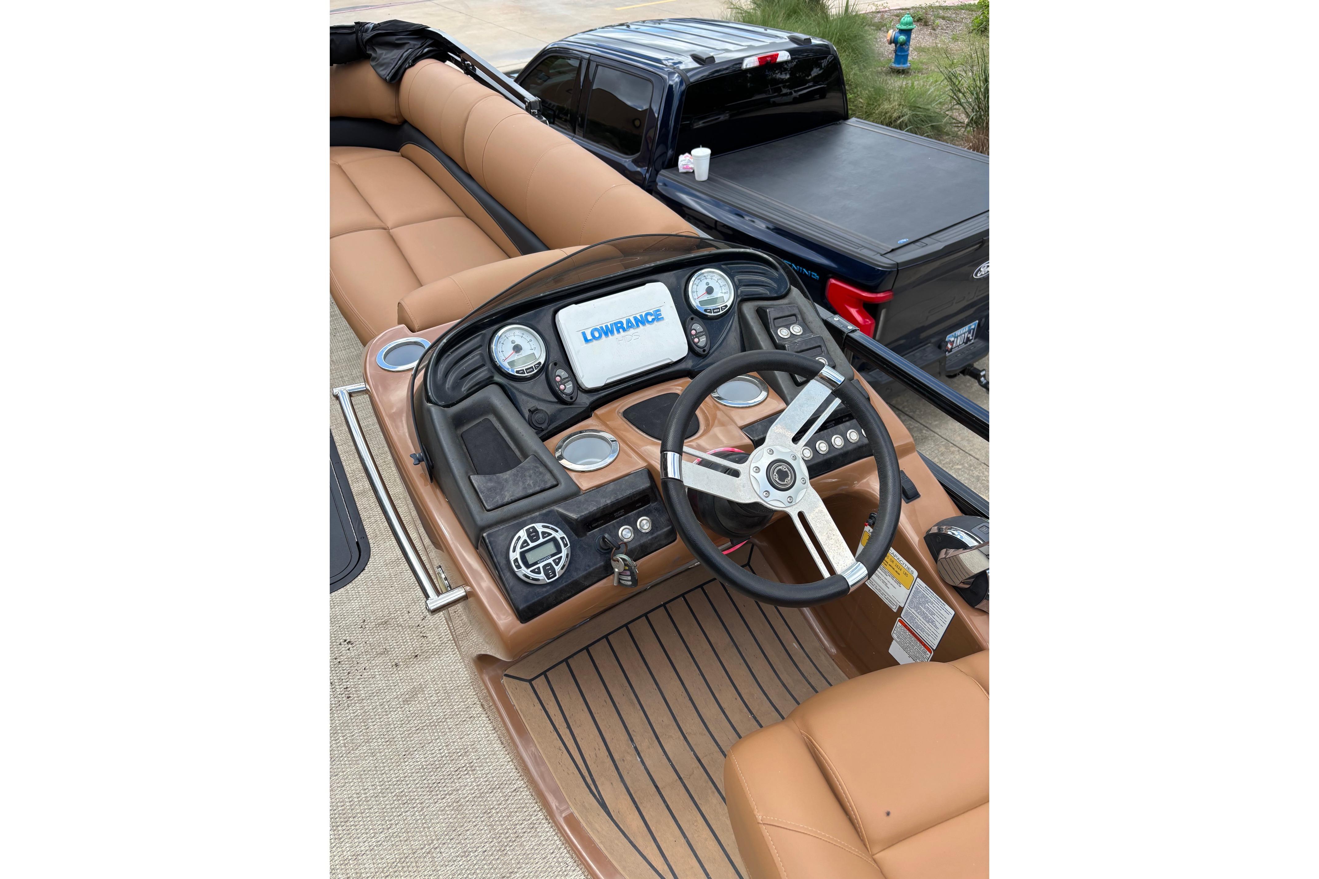 2018 Regency 254 LE3 Sport boat dashboard with Lowrance display and tan seating.