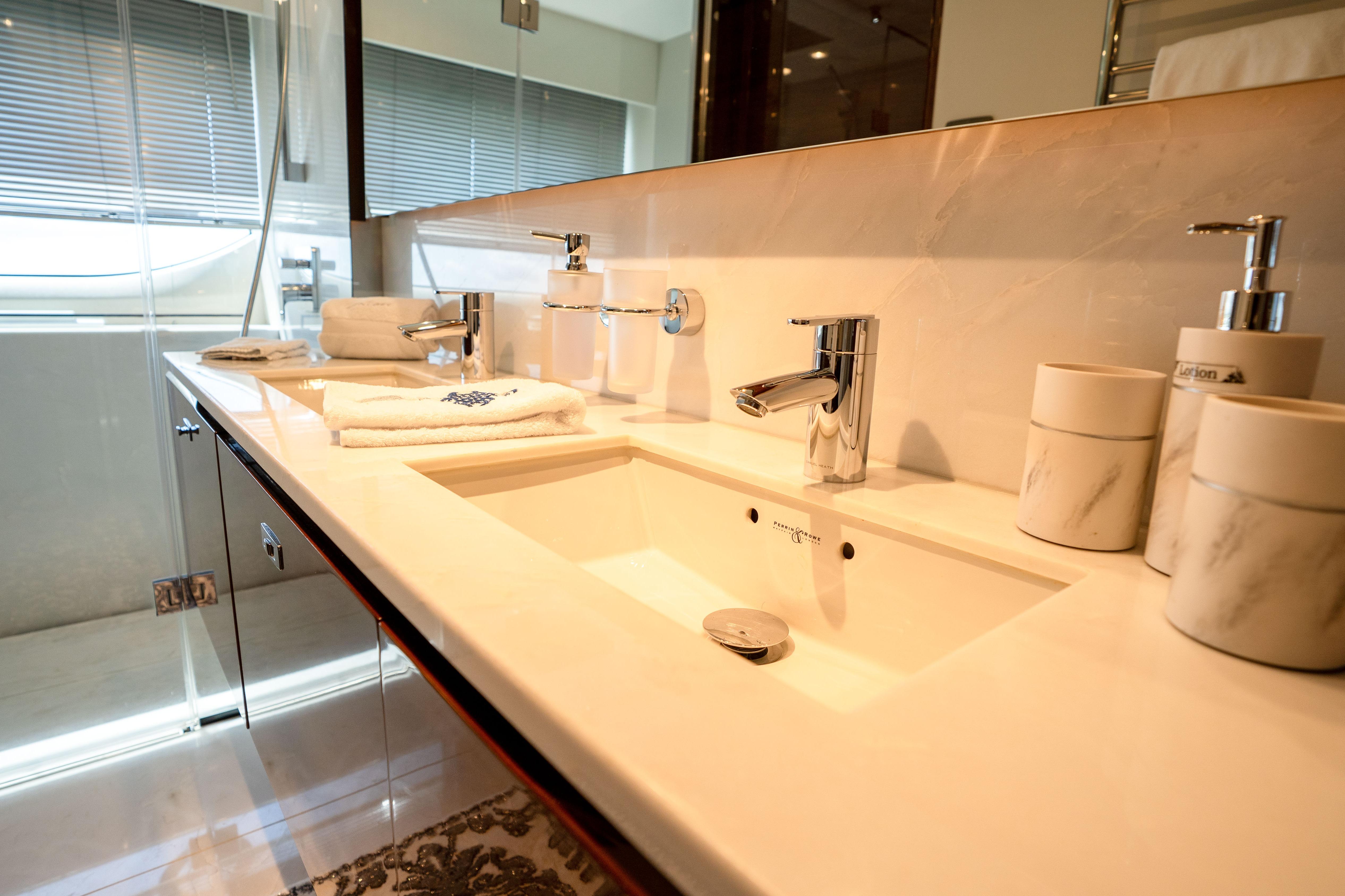Luxurious bathroom sink area on a 2020 Princess Y85 yacht, featuring elegant fixtures.