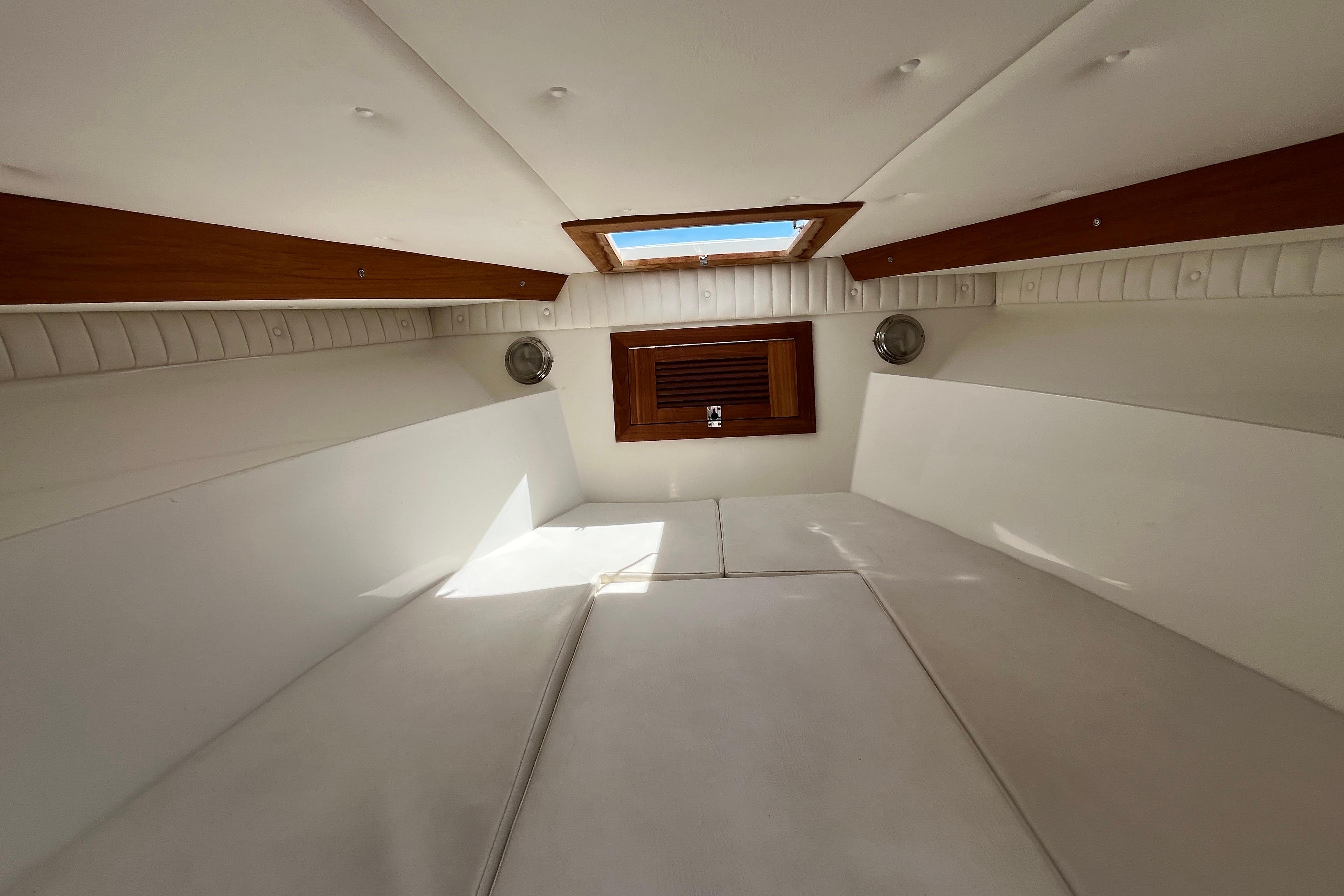 Interior of a 1994 Intrepid 30 Open Cuddy, featuring white cushions and wooden accents.