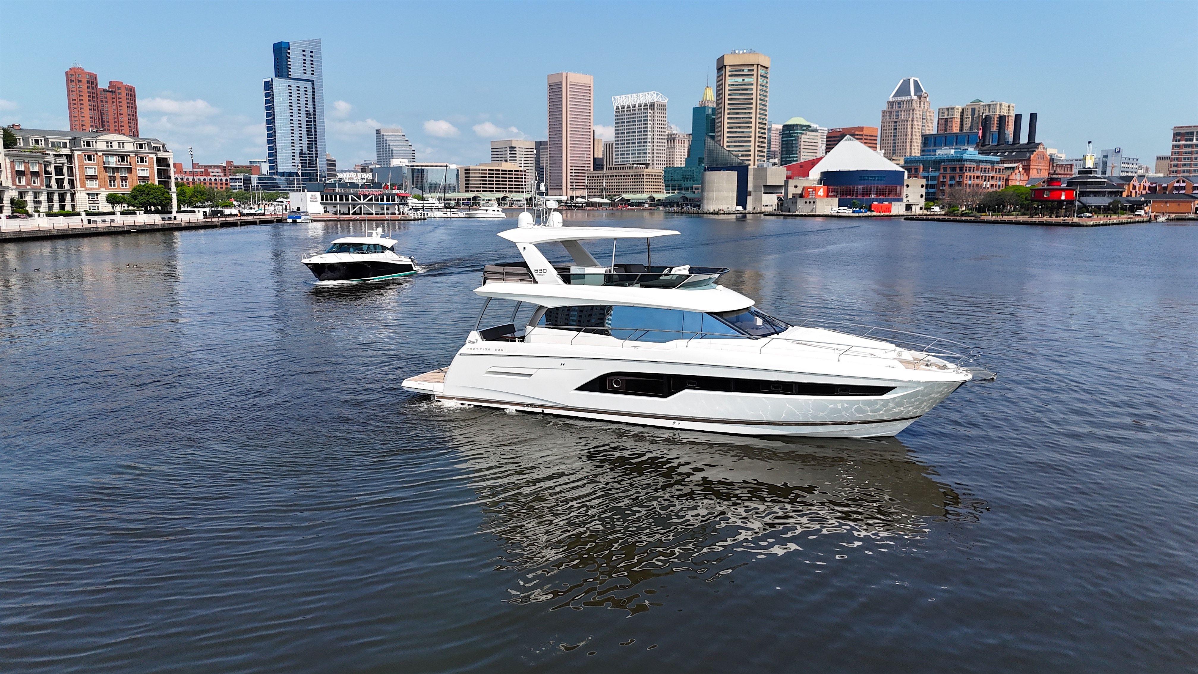 2017 Prestige 630 yacht cruising in urban waterfront setting.