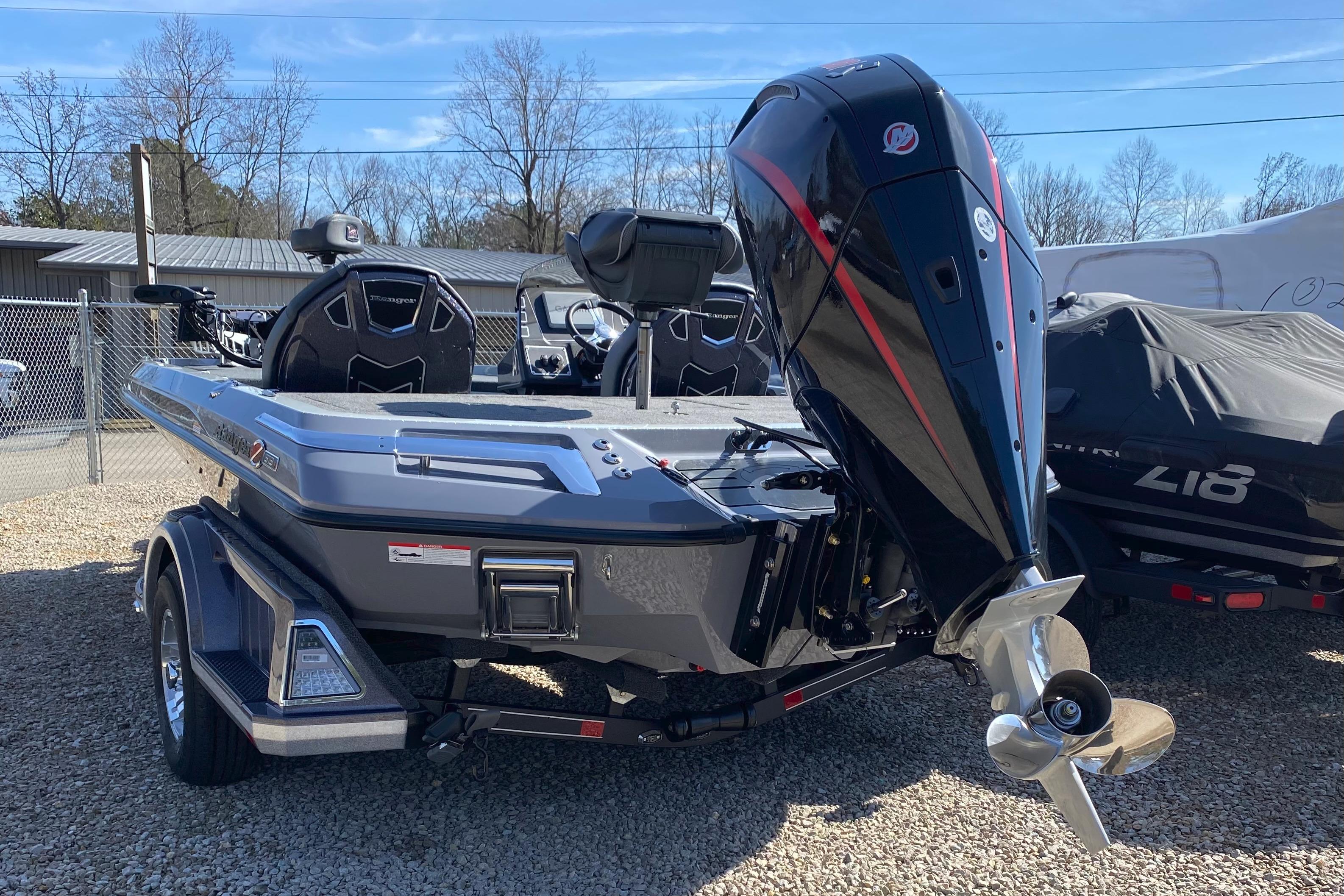2026 Ranger Z519R boat with powerful outboard motor, parked on gravel lot.