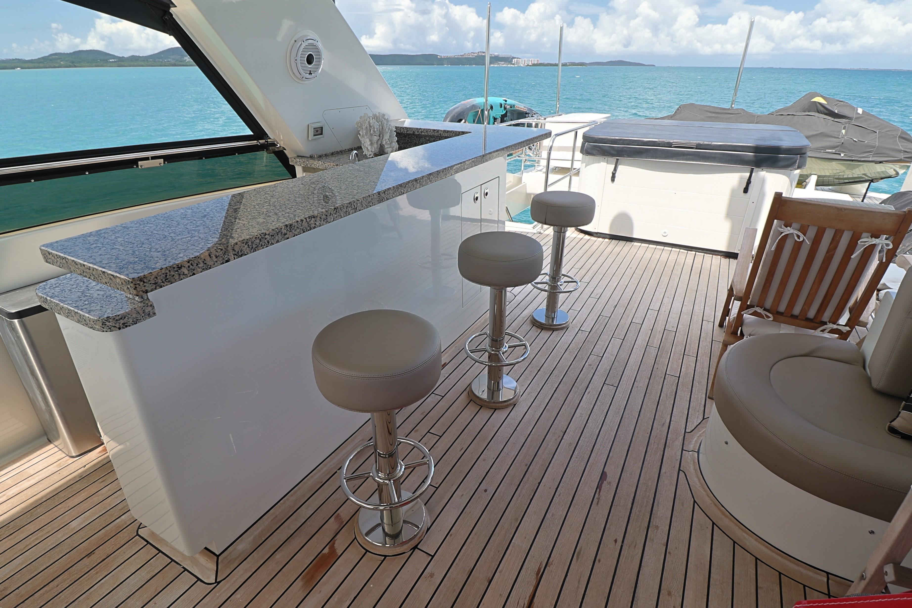 Luxurious 2013 Cheoy Lee Bravo yacht deck with bar stools and ocean view.